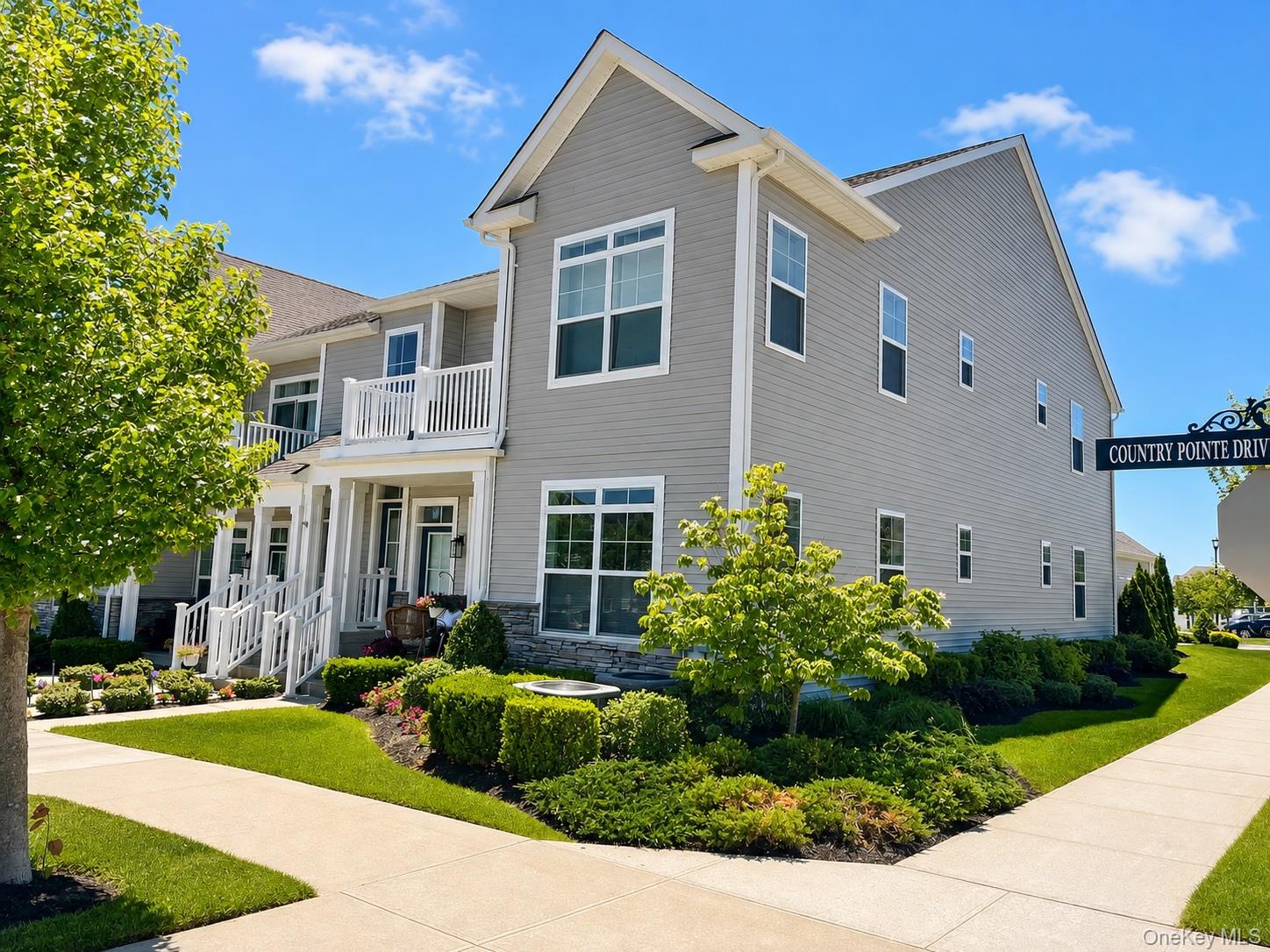 Incredible Opportunity! Why wait 12 or more months for new construction when you can move right into this spectacular, fully upgraded, fully furnished luxury residence and start enjoying country club living immediately? Welcome to one of only two highly sought-after Bradford corner models in the community, a sun-drenched end unit offering exceptional natural light from the east, north, and west, an open-concept floor plan, soaring 14-foot vaulted ceilings, and designer finishes throughout. This extraordinary home has been extensively customized with approximately $85,000 in premium upgrades, creating a true turnkey opportunity where every detail has already been completed for you.At the heart of the home is a spectacular designer chef's kitchen built for everyday living and unforgettable entertaining. Showcasing elegant white cabinetry with under-cabinet lighting, premium quartz countertops, a custom tile backsplash, stainless steel appliances, and an enormous center island with pendant lighting, prep sink, and abundant seating, this incredible space naturally becomes the gathering place for all. The kitchen flows seamlessly into the spacious living and dining areas, where soaring ceilings, recessed lighting, designer fixtures, and walls of windows create a bright, open atmosphere perfect for entertaining or relaxing at home. Whether hosting holiday gatherings or enjoying a quiet evening at home, this thoughtfully designed layout delivers the perfect balance of luxury, comfort, and functionality.Enjoy the convenience of your own private elevator, a rare and highly desirable feature providing effortless access to the main living level. The home also offers front and rear private entrances, a spacious private second-floor deck accessed through sliding glass doors, abundant closet and attic storage space in both the 2nd bedroom and garage, LG washer and dryer, custom hardwood flooring, upgraded banisters, designer imported wallpaper, premium lighting package, high-speed EV charging capability in the garage, and countless custom finishes that truly set this residence apart.The luxurious primary suite serves as a private retreat featuring designer accent walls, elegant lighting, generous closet space, and a spa-inspired ensuite bathroom with an oversized floor-to-ceiling glass shower, premium stone finishes, double vanity, and dual mirrors. A spacious guest bedroom and beautifully appointed full guest bathroom provide ideal accommodations. Best of all, all furniture, televisions, and furnishings are included, allowing you to simply unpack and begin enjoying your new home from day one. Beyond your front door, experience exceptional resort-style living within this beautifully maintained 24-hour guard-gated community. The stunning approximately 11,000-square-foot clubhouse offers an impressive collection of amenities, including a state-of-the-art fitness center, yoga studio, elegant lounge with bar and fireplace, ballroom, card room, sauna, steam room, two heated swimming pools, cabanas, outdoor bar and lounge with TVs, fire pits, barbecue areas, tennis, pickleball and bocce courts, plus an active social calendar filled with events, clubs, and activities. Adding even more value, this exceptional residence benefits from low property taxes, making luxury country club living even more affordable. Nestled against acres of parkland, you can easily access miles and miles of Long Island walking trails. Perfectly positioned just minutes from major roadways, shopping, restaurants, Starbucks, Paris Baguette, Southpaw Brewing Company, Northwell Health, Walmart, and everyday conveniences, this remarkable residence offers the perfect combination of luxury, lifestyle, location, and immediate occupancy. A rare opportunity to own one of the community's most desirable and extensively upgraded homes, where every upgrade has already been completed. Simply unpack, relax, and enjoy the lifestyle you deserve.