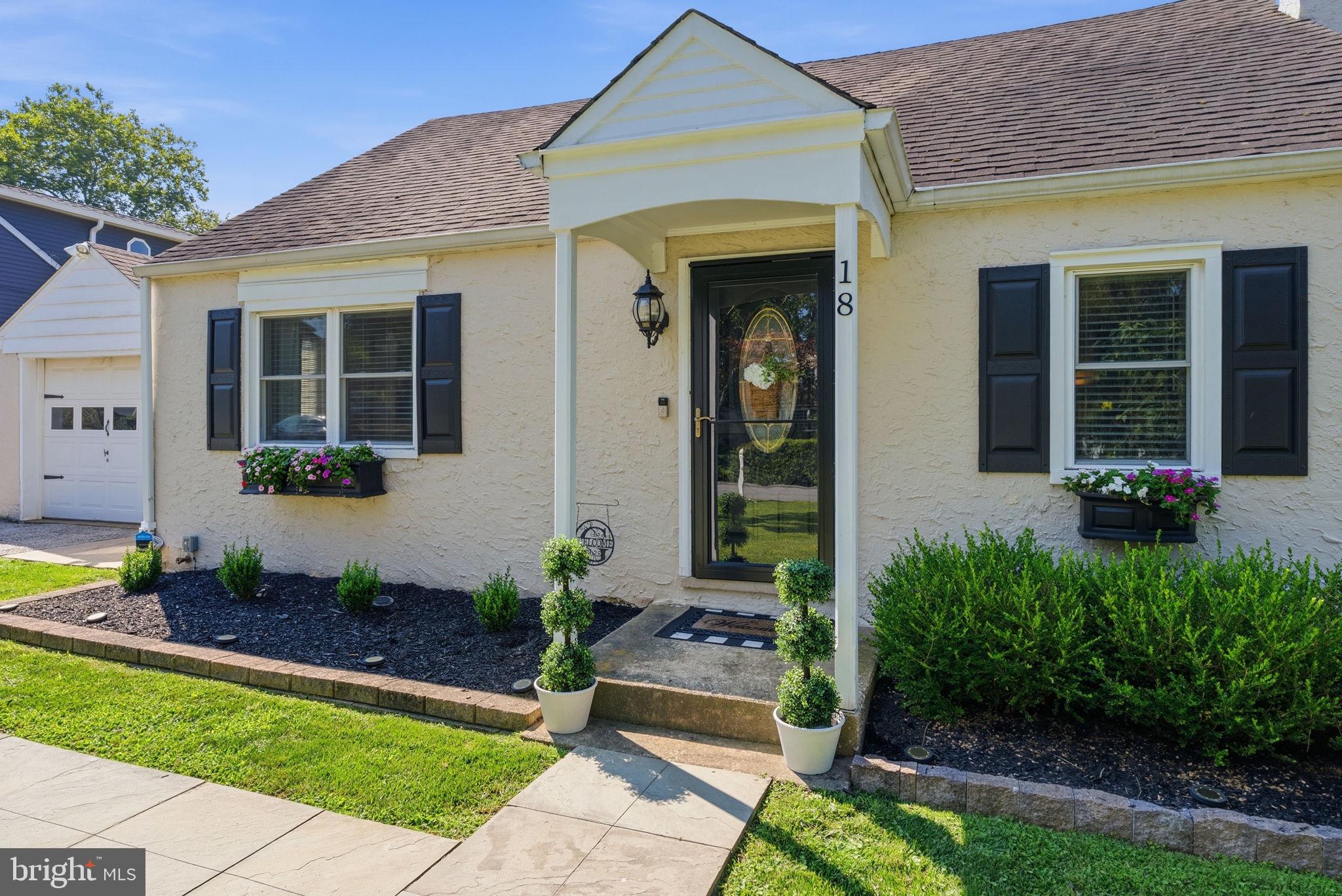 Charming Cape Cod curb appeal welcomes you home to 18 Buttonwood Ave. Set on a beautifully landscaped lot with mature plantings, flower boxes, and a covered front entry, this 3-bedroom, 2-bath home offers over 1,300 square feet of thoughtfully updated living space. Inside, gleaming hardwood floors flow through the living room — anchored by custom shelving — and into a dining area with a beautiful China cabinet, ideal for entertaining. The updated white kitchen features granite countertops, stainless steel appliances, and ample cabinet storage. A first-floor bedroom and full bathroom add everyday flexibility, while upstairs you'll find two additional bedrooms with charming dormer ceilings and a full bath. The lower level offers a versatile recreation room, perfect for a home gym, playroom, or office. Outside, the expansive backyard is a private retreat with a pergola-covered patio and mature trees, plus a detached garage connected to the home by a breezeway. Ideally located near shopping, dining, and commuter routes, this move-in-ready home blends classic charm with modern updates throughout. Welcome home to 18 Buttonwood Ave!