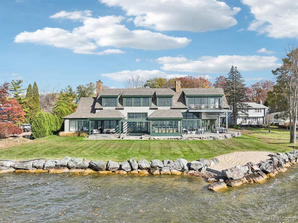 Nestled on all-sports Lake Fenton, this extraordinary lakefront home offers 144 feet of coveted frontage on nearly half an acre of private, waterfront paradise. Thoughtfully reimagined with meticulous craftsmanship, this home combines a warm, modern aesthetic with high-quality materials for premium lake living. The living room centers around a custom stone fireplace, complemented by a family room and sunroom that invite an abundance of natural light and showcase sweeping lake views. The gourmet kitchen, with custom cabinetry and high-end finishes, opens directly to the outdoor space, where a hard-packed sandy beach awaits just steps away for direct water access. On the main floor, a thoughtfully designed guest suite offers privacy with a full bath, ideal for family or friends. Upstairs, the primary suite is a true sanctuary, boasting panoramic lake views, a custom-designed closet, and a spa-like ensuite bath with luxurious finishes. Two additional bedrooms, a full bath, and a cozy sitting area add comfort and functionality, while an optional 5th bedroom or guest suite above the garage includes a private bath, providing versatile living arrangements. The outdoor space is a retreat in itself, with western and southern exposures that frame unforgettable sunsets. An oversized, saltwater hot tub invites relaxation, while the expansive yard offers both privacy and endless views. With heated tile floors on the main level, all-foam insulation throughout, and conveniently located laundry rooms on both floors, this home ensures year-round comfort. Blending elegance, quality craftsmanship, and a one-of-a-kind setting, this property is the ultimate Lake Fenton retreat. ALSO AVAILABLE FOR LEASE