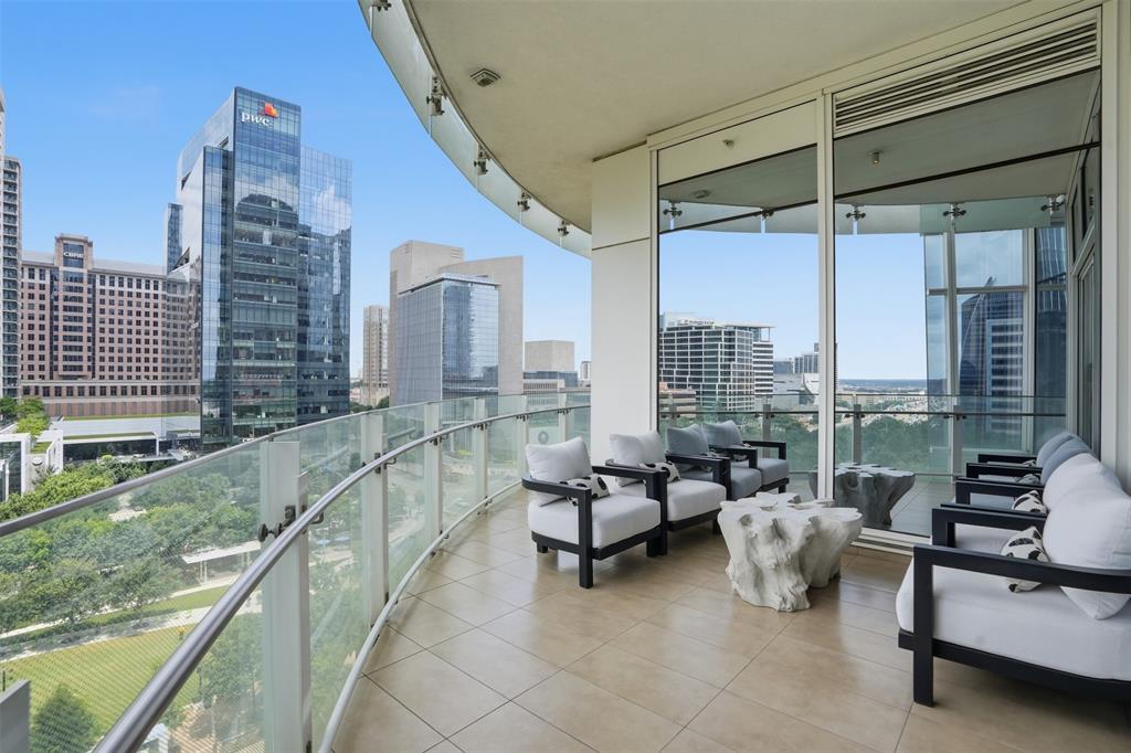 Museum Tower was created to cater to patrons of the arts and art itself, and 704 is perfectly situated for this, offering a bird's-eye view of the Nasher and the DMA. Positioned to embrace a northwestern panorama, it commands unobstructed vistas of Klyde Warren Park, the Arts District, and a downtown writing its next chapter, including new restaurants and the future home of the Texas Stock Exchange. Its elevation ensures the park below remains a natural extension of your home. The reimagined floor plan opens into a seamless flow of city and light: gracious living and dining, a generous primary suite, a second bedroom currently used as a study, light wood underfoot, and walls kept quiet for the art. Award-winning Porcelanosa curated a kitchen featuring custom cabinets and striking Xtone countertops, anchored by a waterfall island made for gathering, a full suite of Miele appliances, with wine storage kept close: a built-in chill and designer racks off the gallery hall. The guest bath has been given over to Warhol's Muhammad Ali, floor to ceiling. The primary claims the skyline, with Reunion Tower in full focus, playing off an abstract art mural, the centerpiece of the room, framing the bed. Mirrored closets carry the view to every angle. Its bath runs long in warm travertine: twin vanities, a soaking tub, a separate shower, and a generous closet with custom built-ins and added storage beyond. A sweeping terrace traces the building's curve, opening off the dining room, then leading to an intimate seat beside the study. The rest is handled for you: valet, a concierge on call around the clock, two Escalade house cars to escort you anywhere within three miles, an eighty-foot pool along a broad lawn, a fitness center and saunas, suites for visitors, and a dog run. A true lock-and-leave, where nothing will have moved but the light. You simply step in and begin.