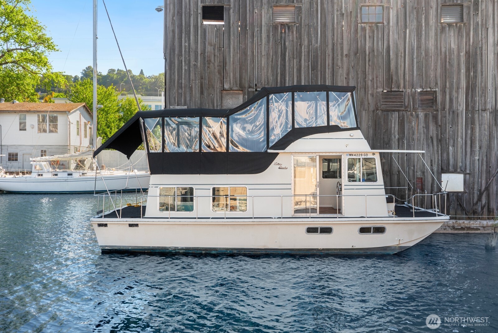 Updated, City-registered houseboat (FOWR 975) on Lake Union offering comfort, charm, and flexibility. Step inside to refinished hardwood floors leading to an updated galley kitchen with seating, fresh paint, new appliances, and fixtures. The light-filled living area features a new propane fireplace for cozy evenings. Below is a private bedroom and updated full bath with new VacuFlush toilet; above, a heated upper deck enclosure with generous seating for guests. All exterior decks have new carpet. Also new: water heater. It can't stay at this location; the seller will assist with relocation—ask your agent for a marina list. Includes 207 sf heated patio within 527 sf total. Seller financing available. FOWR 975.