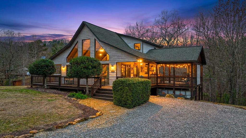 Discover mountain living at its finest in this stunning 2 bedroom, 2 bath chalet located in the beautiful Wildcat gated subdivision of Murphy, NC. Situated on just over an acre of mostly flat, usable land, this property offers a rare combination of privacy, comfort, and outdoor living spaces designed for all-season enjoyment.  Step inside to find an inviting open layout with a full bedroom and bathroom on both the main and upper levels, ideal for hosting guests or multigenerational living. The home includes walk-in closets, surround sound, and warm rustic charm throughout.  The real showstopper is the expansive wraparound deck, complete with tongue-and-groove ceilings, multiple fans, and exceptional outdoor amenities. Relax by the outdoor stacked stone fireplace, unwind in the hot tub, entertain at the outdoor wet bar, or gather around the fire pit on cool mountain evenings. Indoor comfort meets outdoor luxury with a second fireplace inside, creating the perfect ambiance year-round.  Whether you're seeking a vacation getaway, a full-time mountain retreat, or a high-demand rental opportunity, this chalet delivers it all with style and convenience. Welcome to your perfect escape in the heart of Murphy. (Hot tub will need repaired)