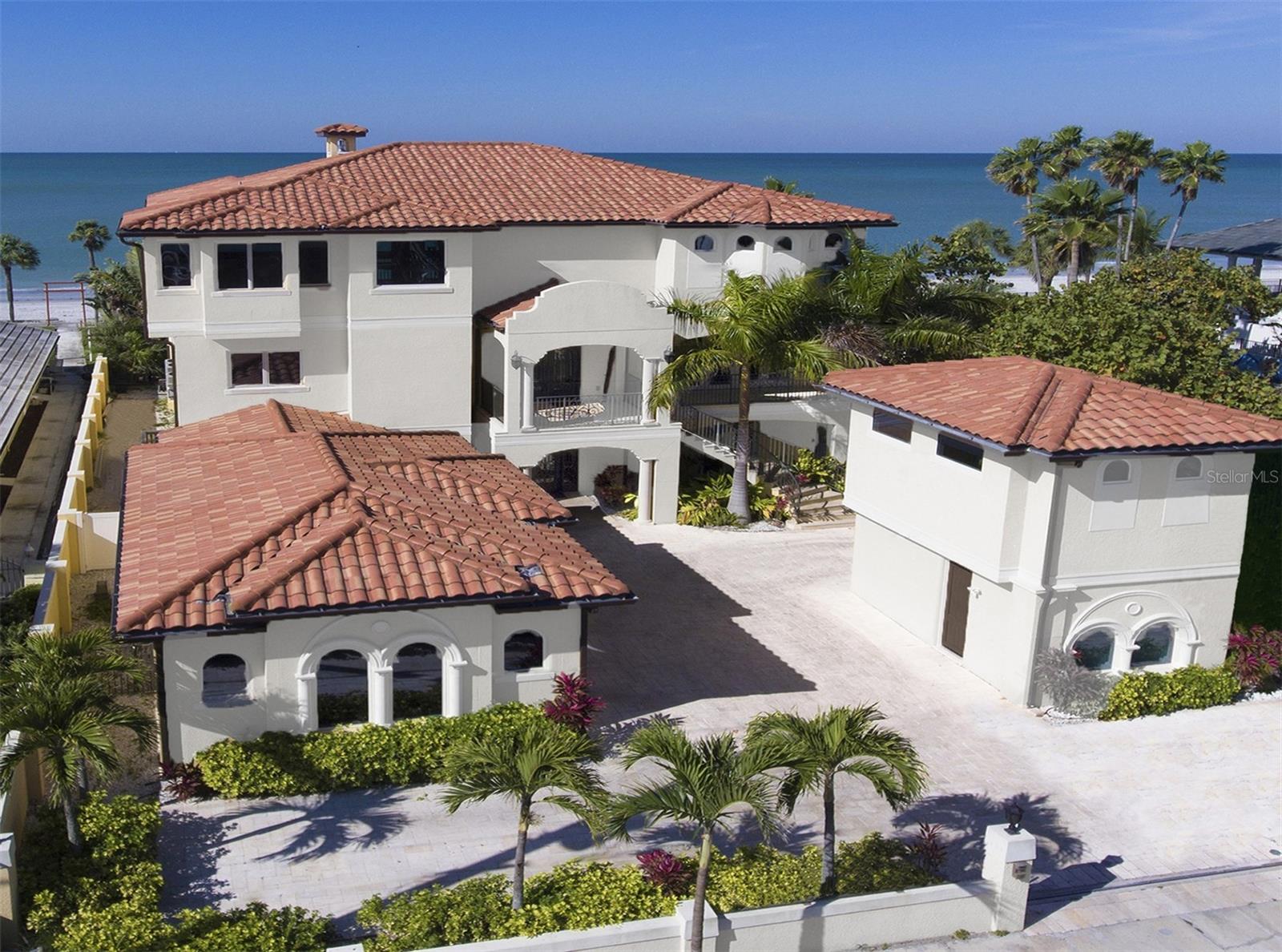 EXTRAORDINARY AND LUXURIOUS BEACHFRONT LIVING IN ONE OF THE FINEST BEACHFRONT ESTATES AVAILABLE IN TAMPA BAY! A masterful and expansive private, resort-style ocean-front estate on a wide 80 feet of pristine natural white sand beach affords endless, unobstructed views of the Gulf. Uncompromising in its architectural details and craftsmanship, this brilliant Tuscan coastal design is situated in a quiet residential area. Your majestic 11,622 total sqft under roof takes advantage of natural light and sweeping water views. Enjoy 6,528 sq ft of resplendent living area, with an additional 3,000 sq ft of superb multi-purpose lower-level space – ideal for entertainment, fitness, gaming and more. Not to be outdone, the detached guest house is perfect for overnight stays or as a nanny’s quarters. Rekindle your joy for cooking in the stunning gourmet kitchen with superb custom designer cabinetry, walk-in pantry, exquisite quartz counters, natural gas cooking, Thermador appliances, lovely island prep center and a separate island dining bar. Relax in the impressive great room with soaring 21ft-high ceilings, Venetian plaster walls, designer gas fireplace, and floor to ceiling window views of the beach/surf. Retire to the luxe owner’s suite and your private balcony with commanding panoramic views of the Gulf, built-in entertainment center, sitting area, fireplace and posh oversized walk-in closet system. Owner’s bath is a sublime, pampering retreat with sumptuous materials, beautifully-encased jetted spa tub, a dazzling walk-in shower design, dedicated cosmetics center and two gorgeous vanities. Three generously-sized guest bedrooms suites, all with water views, are elegantly-appointed with graceful full baths and two private balconies overlooking the beach. Never miss a sunset on your private 1,000 sq ft beach patio – only steps away from white, powdery sand. You'll love the 1,400 sqft of balconies, plush oversized central elevator, a spacious state of the art gas-heated salt-water swimming pool/spa with LED light show, Travertine pavers that are cool to the touch, zero maintenance pet turf and fine landscaping. Relish romantic beach walks, fishing, skimboarding and windsurfing. A grand driveway and attached garage provide parking for up to ten vehicles. This residence was engineered to exceed hurricane standards/building codes with superior all block construction, spray-foam insulation, concrete tile roof and coastal Impact turtle windows. Beautiful limestone and wood flooring, spectacular designer lighting, extraordinary ceiling contours/finishes, epoxy garage flooring, and so much more. Located only minutes away from choice restaurants, shopping, and entertainment. With two international airports within 20 miles, you will easily stay connected. One of the most desirable beachfront homes on Florida’s Gulf Coast – your oceanfront paradise awaits!