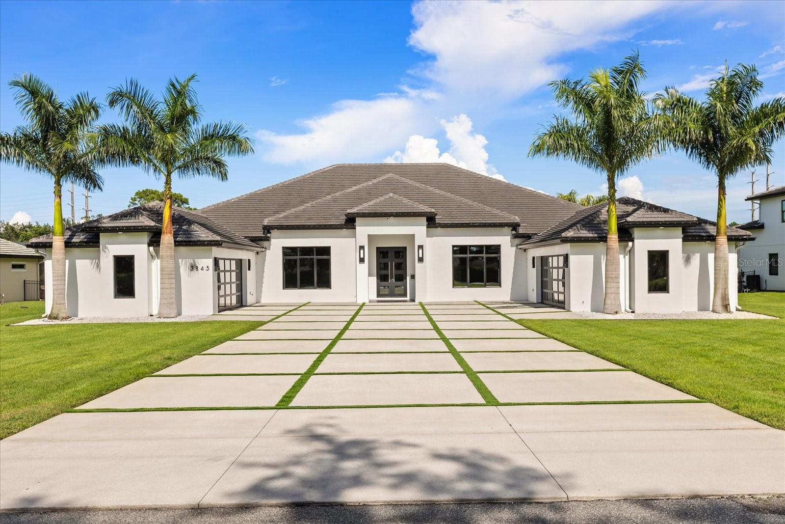 This custom-built, single-story masterpiece sits on just over an acre of manicured grounds in the heart of Lake Mary, offering an exceptional blend of modern elegance and everyday comfort. A 4-car garage with custom showroom floors and a turf-accented driveway sets the tone for the sophistication within. Inside, 48"x48" tile floors, level 5 drywall, soaring ceilings, and an open great room design create a dramatic yet inviting space for both grand entertaining and intimate gatherings. The show-stopping kitchen is a chef’s dream, featuring double quartz waterfall islands, top-of-the-line appliances including a gas cooktop and wine refrigerator, two dishwashers, and a hidden pantry. A glass enclosed wine display adds a striking focal point, while corner-sliding glass doors blur the line between indoor and outdoor living. The primary suite is a true private retreat, offering direct access to the back patio, a large custom walk-in closet, and a spa-inspired en-suite with an oversized walk-in shower featuring dual shower heads, and a double vanity. With five bedrooms—including one currently used as a sophisticated home office—and a large bonus/media room, this home offers remarkable flexibility. Automatic window shades, a security-ready office setup, two secondary bedrooms with private en suites, and an oversized “Costco” closet with a well-appointed laundry room add practical luxury. Step outside to an expansive lanai with hurricane-rated motorized screens, an outdoor kitchen, and a resort-style saltwater pool with basketball hoop and turf-lined deck, all framed by lush palm and bamboo landscaping for ultimate privacy. Located minutes from A-rated schools, upscale shopping, and fine dining, ready for you to move in and begin living the Lake Mary lifestyle at its finest.