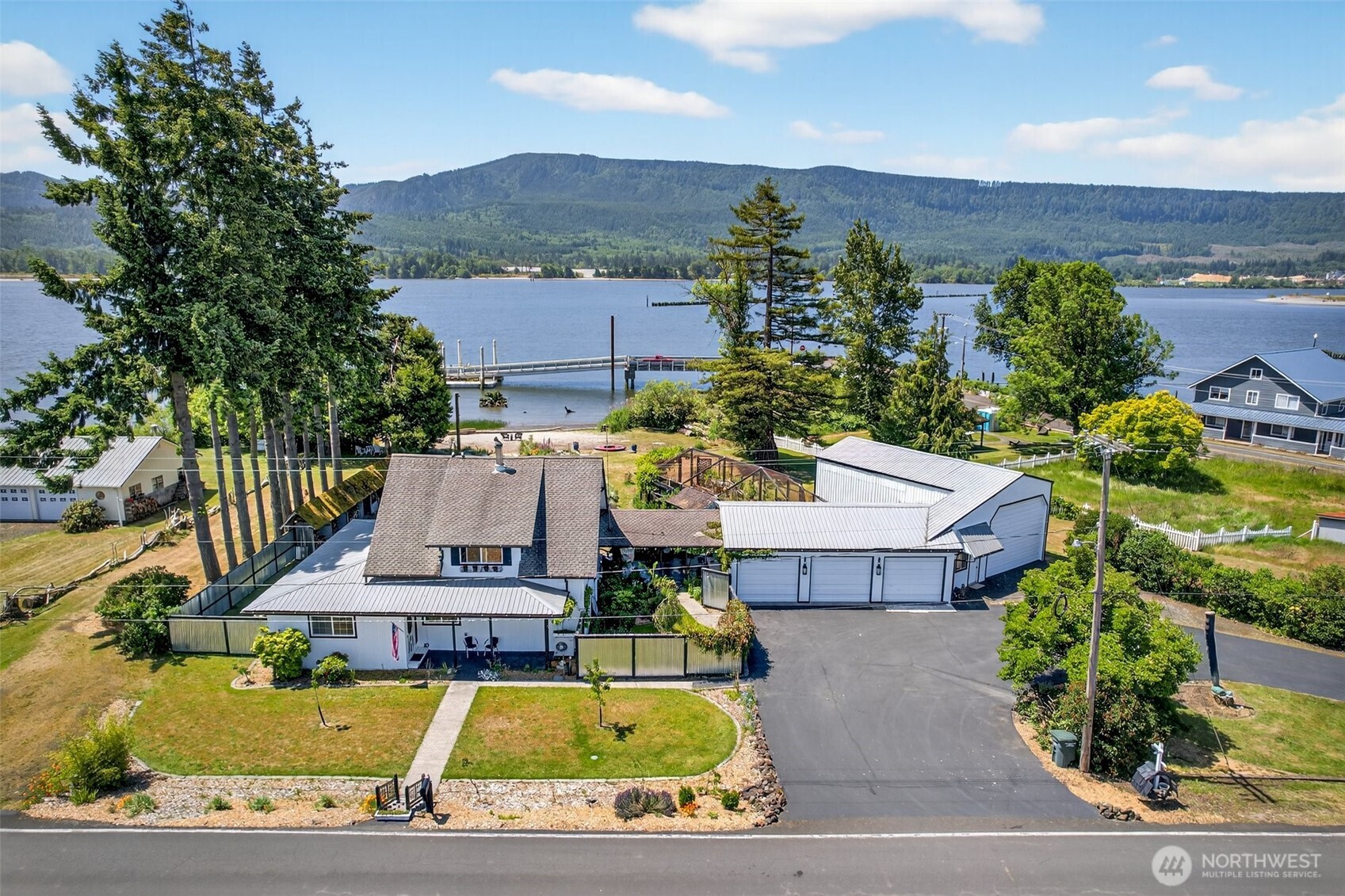 RIVERFRONT Modern country home offers a sandy beach on the Columbia river. Open plan living blends old & new. A farm style kitchen, dining room adjoins living room w/wood stove , separate Library/TV room. Master has large closet and roman tile ensuite. Upstairs-3 large bedrooms with views and a mezzanine area overlooking the river. Attic has 864 SF for your creativity. A covered breezeway leads you to 2136 SF of shops. 13' doors on RV shop, separate entrance to tool shop w/possible ADU potential. Multiple covered parking for the car enthusiast, 2 RV Glamping spaces by beach, 1272 SF enclosed garden Conservatory w/ greenhouse & shed and chicken coop to complete this country home.