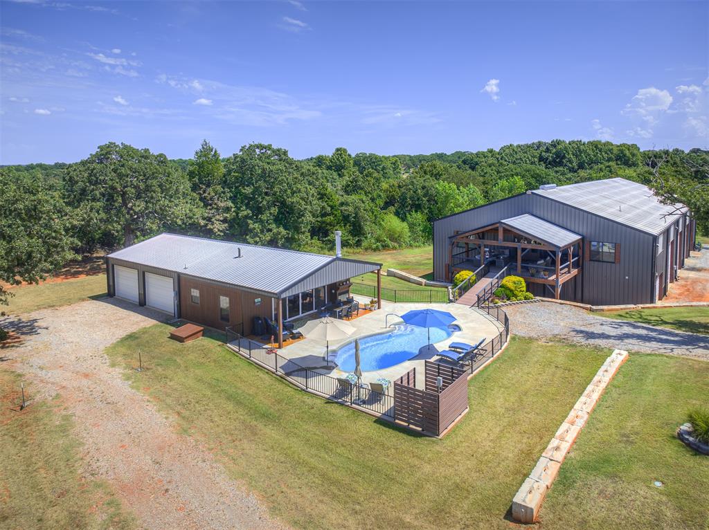 Wait until you see this extraordinary custom 3 beds/3.5 bath, barndominium home on 5 acres in East Norman, OK where you can work from home. This was a builder's personal home and every detail was addressed during its 2021 construction. The entire house has 9' ceilings and large rooms. All cabinets and trim work were custom made for this home. The gourmet kitchen with large walk-in pantry has a window looking into the shop area. The master bathroom is a dream with his/her separate sinks, showers, toilet rooms and closets. Watch family and friends play in the pool from the 20' x 27' covered porch area. The 600sf pool house with 900sf garage was built for parties with its commercial kitchen, bar area and porch overlooking the pool. The shop area is 60' x 100' (6000' )with 22' eve height so whether you collect cars, want a working shop next to your home or see your horses from the kitchen window, this property has the options. The shop has an indoor RV hook up with full hook ups, and an outdoor RV hook up with their own designated septic. This property has a truly private setting with large oaks and abundant wildlife. 20 minutes to center of Norman and OU campus, 40 minutes to OKC, and 2.5 hours to DFW. No HOA. New gated private driveway 0.6 miles south of Highway nine. Bring your horses and other critters and get ready to enjoy country living in this wonderful new home. Additional features list is the last photo.