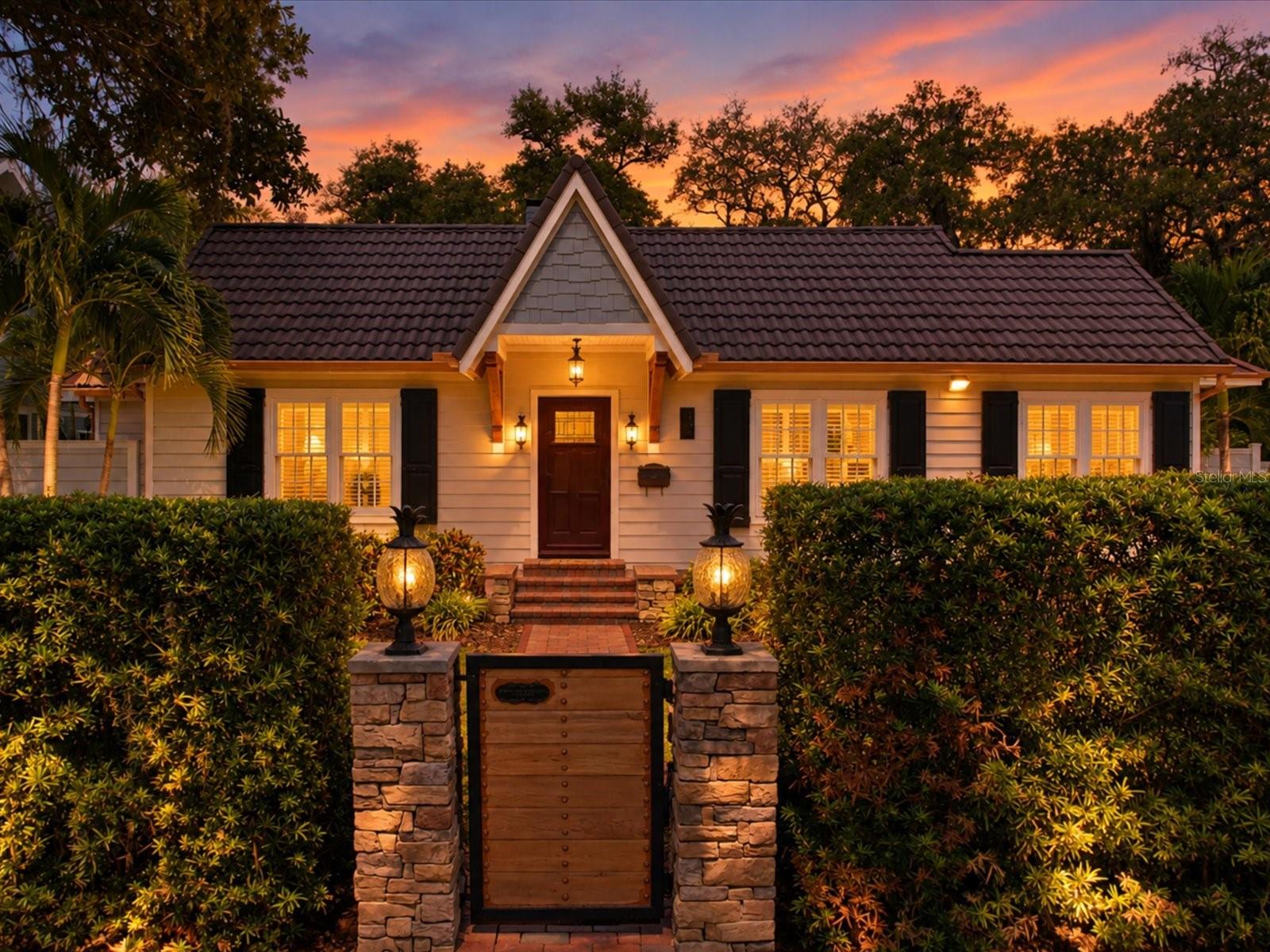 Under contract-accepting backup offers. Historic Harbor Oaks charm meets a backyard made to wow! Set on a gated corner lot beneath mature oaks, this beautifully remodeled 1940s bungalow pairs original character with exceptional modern upgrades. Pella impact windows, Hardie board siding, a tile-inspired metal roof and a five-car carport add to its appeal. Inside, pristine original hardwood floors, plantation shutters and a striking stone fireplace welcome you into the bright, open living room. The chef’s kitchen is a showpiece, featuring leathered granite countertops, high-end KitchenAid appliances, slate floors, glass-front cabinetry, a pot filler and a statement-making Futuro Murano range hood. The primary suite leads to an oversized bath designed for indulgence. Soak in the 72-inch copper-coated claw-foot tub beneath an overhead rain shower or unwind in the custom walk-through steam shower with mood lighting and river rock flooring. A private outdoor garden shower offers another way to recharge. You’ll also find a walk-in sauna, a TV built into the vanity mirror, heated floors in the second bath, and a new stackable washer and dryer concealed behind a glass mirror in the primary bath, keeping laundry convenient while saving valuable space.And then there’s the outdoor oasis: a private splash pad with cascading waterfalls, dual shower heads, and gusher jets. Surrounded by lush green space and an irrigated garden, it’s a setting built for relaxing or entertaining. Additionally, a spacious shed with electricity and newer AC wall unit offers flexible room for hobbies, a workshop or storage. World famous Clearwater Beach, Coachman Park, the Pinellas Trail and more are all nearby. This magnificent property is truly a MUST-SEE!
