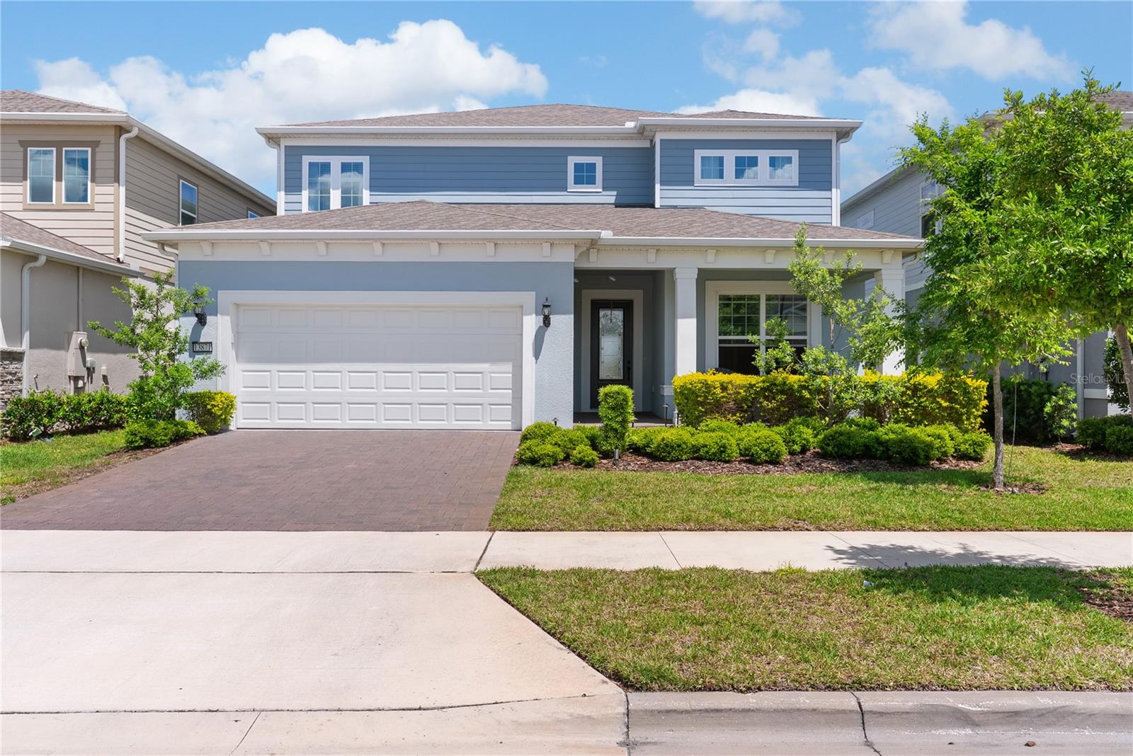 Built by Pulte in 2023 in the gated community of Isles of Lake Nona, the Yorkshire floor plan delivers 3,641 square feet across two stories, with 5 bedrooms, 4.5 baths, and three separate living zones stacked around a central kitchen.Wide-plank wood-look tile runs the length of the main floor. The kitchen anchors it with white perimeter cabinetry, a charcoal island in quartz that seats four, a gas cooktop under a stainless hood, a built-in wall oven, and a patterned black-and-white backsplash that turns the whole cooking wall into the focal point.The living room opens off the kitchen with a geometric paneled accent wall and sliders that put the fountain directly across from the couch. The dining room tucks into its own corner with a shiplap wall.Off the foyer, a flex room behind glass French doors works as an office or a second sitting room, and the ground-floor bedroom across from it has a full en-suite bath and a walk-in closet, a real guest setup for visiting family.Upstairs, the primary bedroom faces the pond, the closet runs nearly 13 feet long, and the en-suite bath pairs gray large-format tile with a glass mosaic accent band, a double quartz vanity with matte black fixtures, and a separate water closet. Three more bedrooms and a full laundry room round out the upper floor. The media room gets its own treatment: floor-to-ceiling charcoal paneling, in-ceiling speakers, and side windows that put the fountain back in frame one story up.Outside, the lanai has a real outdoor kitchen built in. Stainless grill, side burner, sink, stone counter. The screen opens to a brick-paver patio, a fenced yard, and an uninterrupted view of the water. The fountain runs all day.Behind the gates of Isles of Lake Nona: resort pool, splash pad, clubhouse, fitness center, sports courts, playgrounds, 24-hour security, and fiber internet included in the HOA. SR 417, Medical City, and Lake Nona Town Center are all minutes out. A lot of Lake Nona homes list a water view. This one lines the whole house up with it.