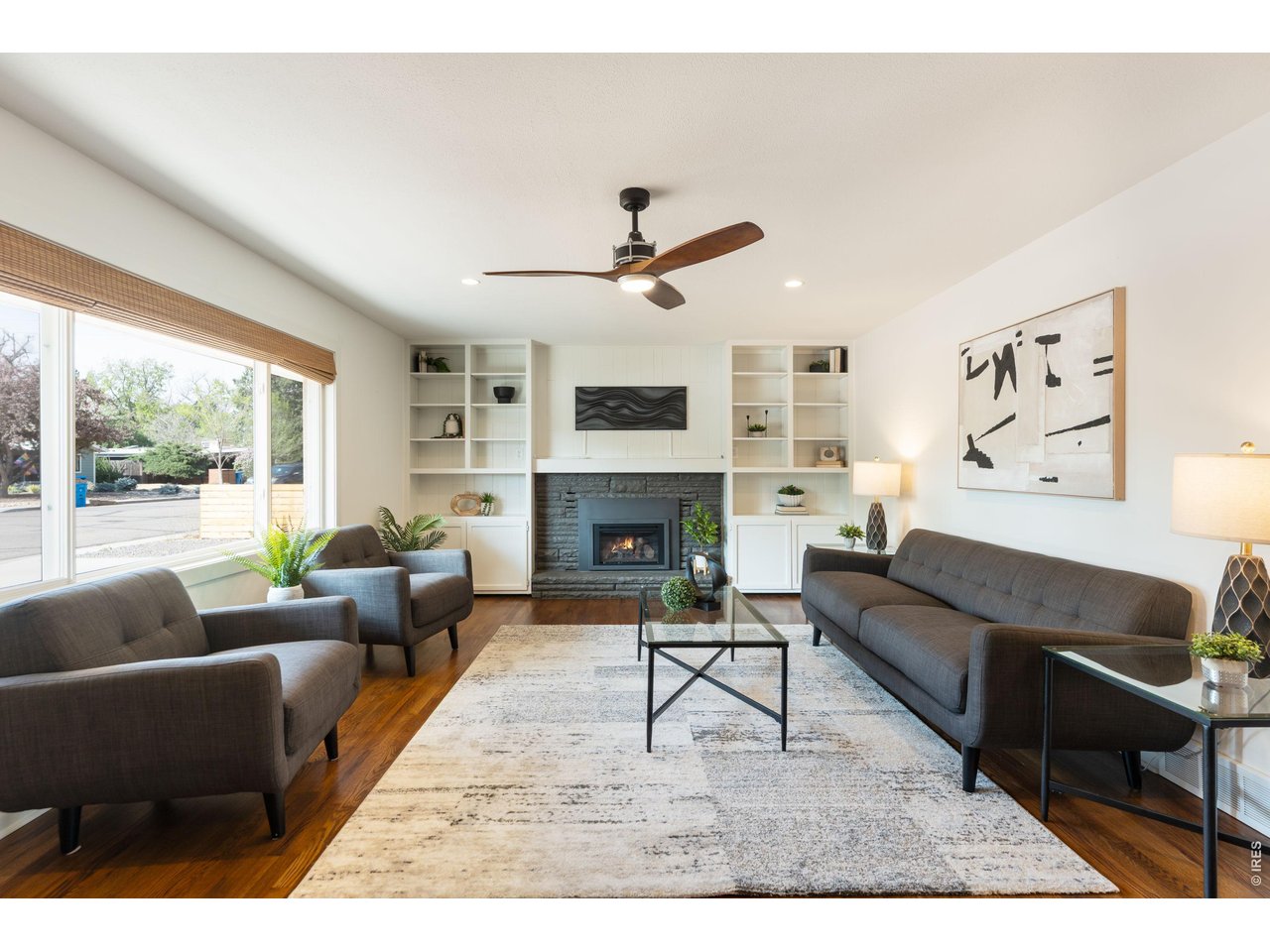 Updated mid-century modern brick ranch in the heart of Old Town Fort Collins, well maintained and thoughtfully refurbished in 2020. This rambling ranch home blends original architectural charm with stylish throwback design, featuring a modernized kitchen with new cabinetry, quartz countertops, and clean, timeless finishes. Hardwood floors run throughout the main living areas and bedrooms, complimented by two updated baths featuring stylish tile and double vanities in the primary. Enjoy a cozy gas fireplace with built-in shelving and extra storage, plus peace of mind with new windows and updated systems including A/C, radon and electrical. The oversized heated garage offers abundant storage in addition to a new outdoor shed, while the low-maintenance exterior and fully fenced yard make everyday living easy. All just minutes from the shops, dining, and vibrant lifestyle of Old Town.
