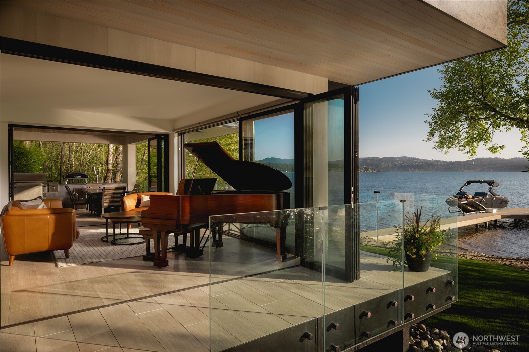 There is a different rhythm to the lake in fall. The water deepens in color, light begins to shift, and the first hints of the season move through the surrounding canopy. This home changes with it. Walnut and stone feel warm against the deeper tones of lake and landscape. When the sun breaks through, light catches the water and the entire interior comes alive. Positioned on 122' of Lake Sammamish waterfront, this McCullough Architects residence was completed in 2023 and designed around an unusually preserved shoreline. Mature trees and native vegetation create privacy, while walls of glass keep water, canopy and changing light ever-present. Expansive NanaWall openings dissolve the boundary between home and lake. The primary bath pairs the Dornbracht AquaMoon shower with integrated spa therapy, while climate, lighting, audio and home systems offer intuitive control on site or remotely. Outside, the covered waterfront terrace takes on a different character as temperatures dip. Firelight warms the terrace, while the lake gathers sky, canopy and architecture into its reflection. Beyond, a sandy beach and private dock draw you toward the shoreline. Step onto the dock. Go to the water's edge. Take in Mt. Rainier. Turn around. See the architecture through the trees, warmth beyond the glass, and layered hills brushed with the first color of the season. From here, house, shoreline and landscape read as one. Come experience Lake Sammamish differently.