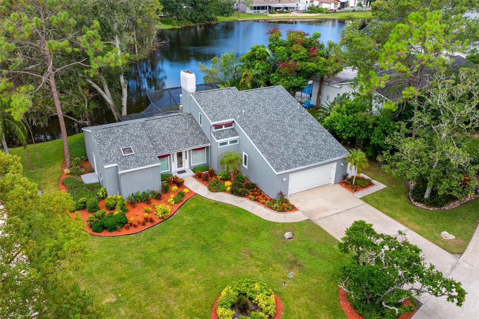 EXCEPTIONAL VIEWS overlooking a private pond and nature beyond in one of Palm Harbor’s most sought-after neighborhoods—AUTUMN WOODS. Well-maintained home sits 26 FEET ABOVE SEA LEVEL, no flood insurance required on over ¾ ACRE. Upgrades include a BRAND-NEW ROOF, GENERAC WHOLE-HOME NATURAL GAS GENERATOR, GAS RANGE, WATER HEATER, and CLOTHES DRYER. Features 3 SPACIOUS BEDROOMS, 2.5 BATHROOMS, an OVERSIZED 2-CAR GARAGE, and a REFRESHED EXTERIOR with newly refurbished and painted siding. Enjoy morning coffee or watch wildlife from the SCREENED LANAI overlooking the POOL AND POND. Open, bright interior with HIGH CEILINGS, WOOD FLOORS, CATHEDRAL CEILINGS, SKYLIGHTS, and a WOOD-BURNING FIREPLACE. The KITCHEN offers GRANITE COUNTERTOPS, VAULTED CEILINGS, a GAS RANGE, and a BREAKFAST AREA with water views. PRIMARY SUITE on the first floor with FIVE-PIECE ENSUITE BATH and WALK-IN CLOSET. Upstairs features TWO ADDITIONAL BEDROOMS and a FULL BATH for family or guests. AUTUMN WOODS offers a DOG PARK, PLAYGROUND, TENNIS, PICKLEBALL & BASKETBALL COURTS, plus TOP-RATED SCHOOLS, including PALM HARBOR UNIVERSITY HIGH. Located approximately 7 miles from Honeymoon Island and Caladesi Island - ½ mile from the Pinellas Trail, which offers access to many surrounding parks, springs, and activities. Clearwater Beach, a world-renowned vacation destination, is under 13 miles away. The St. Pete-Clearwater International Airport is conveniently located 17 miles away, with Tampa International Airport under 22 miles away.