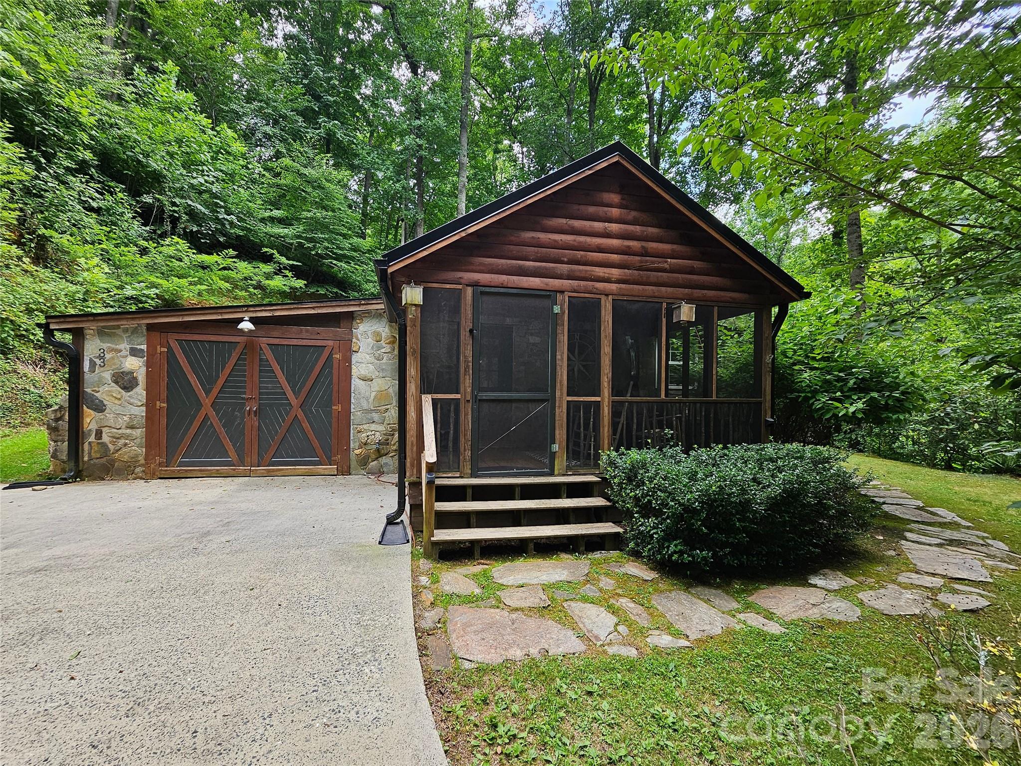 Cozy Cottage in the Famous Cattail Creek Community at 3,500' Elevation in Burnsville North Carolina. Perfectly placed half way up Mount Mitchell, the Cattail Creek Community is almost completely surrounded by Mt. Mitchell State Park!  This beautifully maintained property features half an acre, a spacious screened in front porch, brand new metal roof, open family room with vaulted ceilings & stone fireplace with gas logs. The most unique stone kitchen that boasts a lovely wood stove. Two cozy bedrooms and two full bathrooms + a loft sleeping or storage area. Oversized one car garage. Private side yard is perfect for grilling out in the summer and fall seasons while listening to the creek in the distance. Incredibly peaceful and surrounded by nature! State maintained road access all the way to Tennis Court Road. High speed internet!