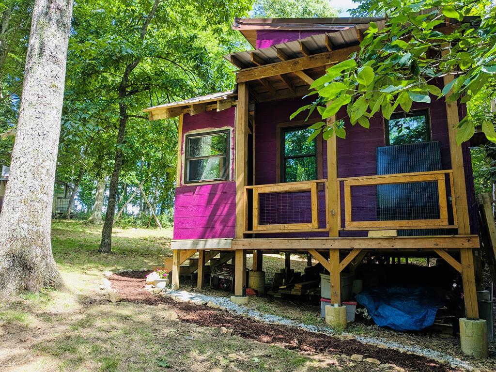 Escape to this unique, owner-built cabin nestled on 1.74 acres in Floyd County. Bordering over 4,000 acres of the Rocky Knob National Recreation Area. The cabin features a cozy main level plus a 250 sq. ft. loft, complemented by expansive front and rear decks for outdoor living. Equipped for total independence, the home features a state-of-the-art solar power system, 350+ gallons of rainwater storage, and a wood-burning stove. The grounds feature a sunny garden with raised beds, established herb gardens, and a variety of young fruit trees (Paw Paw, Persimmon, Pear, and Plum). Wander past the rhododendrons to find a secluded clearing featuring a wood-fired bathtub the ultimate spot for stargazing. While you'll feel worlds away, you are just 0.8 miles from the Blue Ridge Parkway and less than 10 minutes from the amenities of Meadows of Dan. Owner financing available come see it today!