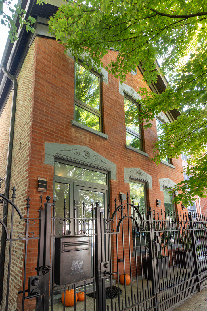 Stunning Luxury Renovation in Chicago's Coveted East Village. Experience the perfect blend of history and modern luxury in this comprehensive 2019 gut renovation by Karisus Design. Situated in the heart of East Village, steps from Wicker Park's acclaimed dining, boutiques, and nightlife, this 4-bedroom, 2.5-bath residence offers the quality of new construction with the character of a timeless Chicago home. Inside, no detail has been overlooked. The home features oak floors with grey-wash stain, bespoke built-ins, designer lighting, and a sleek fireplace accented by striking stone and hand-hewn millwork. The thoughtful layout includes FOUR bedrooms upstairs with laundry on the same level. The chef's kitchen is a showpiece, boasting custom cabinetry, Thermador appliances, built-in Gaggenau coffee system, wine fridge, and more. The family room is drenched in natural light from floor-to-ceiling custom French doors, creating an ideal flow for both everyday living and entertaining. Step outside to a fully built-out private patio with custom planters, reclaimed wood fireplace, and elegant seating.Retreat to the primary suite with soaring cathedral ceilings, spa-inspired bath with heated floors, freestanding tub, dual vanity, and separate shower. Custom closets and a built-in desk round out the suite. The property is completed by a full two-car garage with EV charging and storage loft.