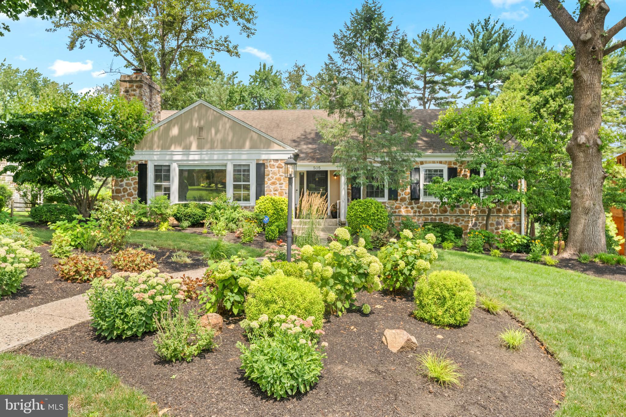 Nestled in the highly sought-after Shortridge Park neighborhood of Wynnewood, 505 Parkview Drive is a true Main Line gem. This beautifully reimagined stone Cape Cod has been meticulously maintained and thoughtfully updated by its current owners, offering timeless charm, modern finishes, and an unbeatable location. Situated within the Lower Merion School District’s highly desirable high school choice zone, this exceptional home offers 5 bedrooms, 3 full bathrooms, and 1 half bathroom.  A charming walkway leads to the welcoming front entrance, setting the tone for what awaits inside. The foyer opens to an expansive living room featuring a classic wood-burning fireplace, custom built-in shelving, and abundant natural light.  From there, the home flows seamlessly into the open dining area and the stunning gourmet kitchen—the true heart of the home.  Completely renovated in 2021–2022, the kitchen showcases crisp white cabinetry, quartz countertops, premium stainless steel Thermador appliances, a timeless counter-to-ceiling white subway tile backsplash, floating wood shelves, an undermount sink, and an oversized center island designed for everyday living and effortless entertaining. The kitchen opens directly into a spectacular great room with soaring vaulted ceilings and dramatic oversized windows that flood the space with natural light while showcasing breathtaking views of Shortridge Park. Step outside onto the spacious deck to continue enjoying the peaceful setting—perfect for morning coffee, outdoor dining, or hosting family and friends. The main level also features a spacious primary suite with a private bathroom, two additional generously sized bedrooms, and a beautifully appointed full hall bathroom. Upstairs, you’ll find a large fourth bedroom with a walk-in closet and an additional closet, another full bathroom, a spacious loft-style living area or home office, and a smaller fifth bedroom. The finished lower level has been refreshed with brand-new carpeting and luxury vinyl plank flooring and offers additional living space, a laundry room, a powder room, and convenient access to the attached two-car garage.  Surrounded by mature landscaping and complemented by a long private driveway, this exceptional property offers a picturesque setting with direct access to the beauty of Shortridge Park right in your backyard.  Enjoy one of the Main Line’s most walkable lifestyles, just moments from Narberth and Wynnewood’s vibrant shops, restaurants, Whole Foods, Starbucks, and two nearby train stations providing effortless access to Center City Philadelphia. This is a rare opportunity to own a truly special home in one of Wynnewood’s most coveted neighborhoods. Schedule your private showing today!