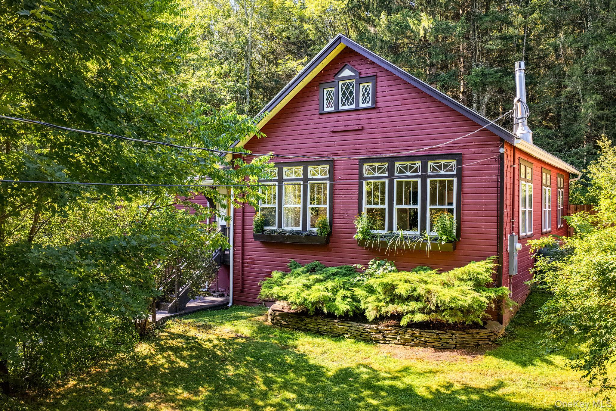 View of side of home featuring a yard and a wooded view