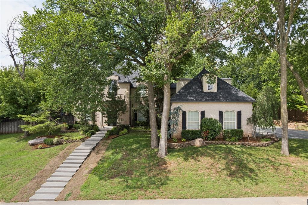 Welcome to 4705 Manor Hill Drive, a beautiful Norman home tucked into a tree-lined neighborhood with impressive curb appeal and timeless architectural character. From the grand entry and sweeping staircase to the rich wood flooring, elegant trim, built-ins, and multiple fireplaces, this home offers warmth, sophistication, and thoughtful detail throughout. The spacious floor plan is designed for both comfortable everyday living and entertaining. The large kitchen features abundant cabinetry, double ovens, an oversized island, and convenient access to a nearby wet bar, while the formal dining and generous living areas provide plenty of room to gather. The primary suite offers a private retreat with a fireplace, patio access, spa-style bath, walk-in shower, jetted tub, and an expansive closet with built-in storage. Upstairs, a flexible living space creates the perfect area for a media room, game room, gym, or additional lounge. Outside, enjoy a private backyard with mature trees, patio space, covered outdoor living, and a beautiful pergola—ideal for relaxing or hosting guests. This home blends elegance, function, and outdoor living in one exceptional Norman location.