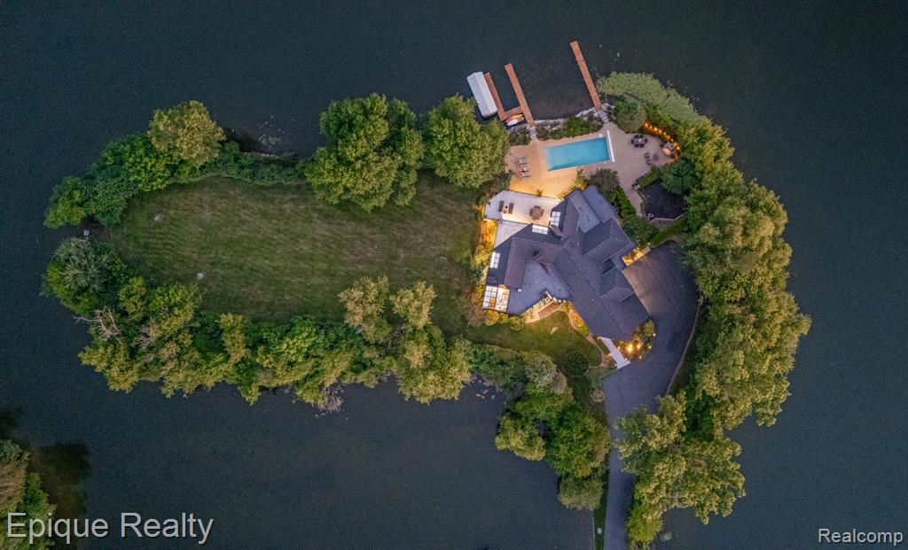 It's no exaggeration in saying that this is truly a once in a lifetime opportunity! This private peninsula estate combines a stunning natural setting with curated design and elevated living. Nestled on nearly 2 secluded acres and wrapped in over 1,000 feet of shoreline, it offers rare privacy, panoramic water views, and a lifestyle few will ever experience.

Step inside to a dramatic rounded foyer, solid maple floors, and architectural ceiling lines. A double-sided fireplace connects the formal dining room to a vaulted great room with exposed beams, accent lighting, and a full wall of glass opening to the outdoors.

The main-level primary suite is a retreat of its own—featuring cathedral ceilings, a walk-through closet, travertine-tiled bath, dual vanities, and a jetted tub. A second main-floor bedroom (or home office) includes a stone-surround gas fireplace and vaulted ceilings.

At the center of the home, the gourmet kitchen is outfitted with quartz counters, Wolf range, Sub-Zero refrigerator, large gathering island, custom KraftMaid cabinetry, and a vaulted breakfast nook with skylights and fireplace.

Upstairs are two generous vaulted bedrooms with a shared ensuite bath and walk-through closet.

The walkout lower level was built for both entertaining and everyday living—featuring a second full kitchen, large rec space, fitness room, fireplace, private guest suite with ensuite bath, full "locker room" style bathroom and an additional flex room.

Outside, enjoy your own lakefront resort: a zero-barrier in-ground pool, hot tub, covered lanai with ceiling fans, and a built-in firepit, all surrounded by lush landscape and water views in every direction. Lake Sherwood is an amazing All Sports Lake with a plethora of lake specific events & community amenities.  Enjoy privacy and serenity with the placement of this home in a no wake zone, or hop in the boat to enjoy watersports and cruising in no time.

Practical updates include four new furnaces, many newer windows and sliders, new roof systems, and a 3.5-car garage