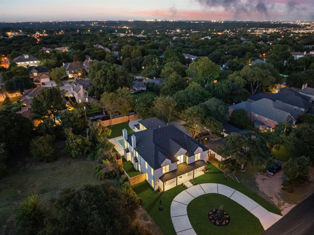 Crafted by the renowned Strange and Sons Development, this architectural masterpiece is a stunning display of luxury, scale, and sophistication. This 6,075 square foot new construction residence offers five spacious bedrooms, five and a half designer bathrooms, a flexible downstairs bonus room, private study, and an expansive upstairs game room, seamlessly blending function and elegance. Soaring 20+ foot ceilings welcome you into a light-filled open concept layout, anchored by wide-plank white oak flooring and curated finishes throughout. The heart of the home is a show-stopping kitchen featuring a twelve-foot island with built-in storage, white oak and alabaster cabinetry, luxury stone countertops, and designer brass fixtures, a true chef’s and entertainer’s dream. Just behind the main kitchen, a fully outfitted scullery kitchen adds both convenience and elegance, complete with an additional full-sized refrigerator and dishwasher, perfect for entertaining or everyday prep and cleanup. Adjacent, a custom wet bar and wine bar offer the perfect setup for sophisticated hosting. The living space opens beautifully to the backyard through a dramatic four-panel sliding glass door, creating a seamless transition between indoor and outdoor living. The luxurious primary suite is a private retreat with a spa-inspired bathroom boasting a massive walk-in shower, Carrara marble finishes, and elegant brass hardware. Each secondary bedroom is generously sized and includes its own en-suite bath and custom closet space. Step outside to your own private oasis, where a covered patio with a built-in outdoor kitchen overlooks a sleek, modern pool. Additional highlights include an oversized two-car garage, designer lighting and high-end hardware throughout, an upstairs balcony retreat, meticulously selected tile and stonework, and energy-efficient systems with smart home capabilities.