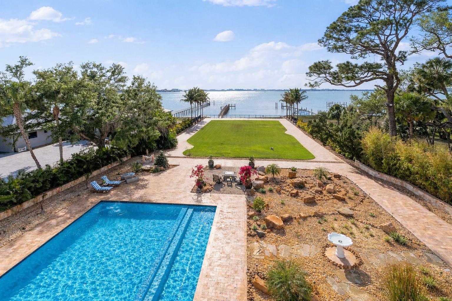Palazzo Sul Mare is a rare waterfront estate in St. Petersburg’s coveted Jungle Prada neighborhood, offering over 19,000 square feet under roof and more than 10,000 square feet of interior living space on over 1.5 acres along the Intracoastal Waterway. Built in 2020, this residence blends modern construction with timeless European-inspired design—an offering rarely found in this market.A grand motor court and porte-cochère create a secure, estate-style arrival. An imported limestone exterior, along with wrought iron detailing, a distinctive blue dome, fountain, marble statuary, and mature oak trees, establishes a timeless setting surrounded by tropical landscaping and the neighborhood’s iconic peacocks. Inside, a dramatic domed rotunda crowned by a crystal chandelier anchors the home, featuring inlaid marble flooring and dual sweeping marble staircases. The layout captures water views throughout, with a gallery-style corridor ideal for art, a grand piano, or entertaining. Marble archways and columns, gold and iron balustrades, and detailed ceilings create a striking architectural presence, while illuminated art niches enhance the home’s scale and design continuity.Custom millwork, fresco-style ceilings, and imported marble flooring span all three levels. The kitchen features a full suite of Thermador appliances, including a 60-inch gas range, integrated refrigeration, and built-in coffee system, along with quartzite surfaces and an illuminated onyx island. A custom Chihuly-style installation of hand-blown glass creates a focal point above, while the curved glass dining area frames panoramic water and pool views with space for large-scale entertaining.The residence includes multiple bedroom suites, several exceeding 1,000 square feet, many with spa baths, expansive closets, and private lanais with water or garden views. The main-level primary suite offers a marble bath with Phylrich fixtures, sauna, soaking tub, multiple vanities, and panoramic water views beneath a custom fresco ceiling.A private office on the main level features paneled walls, built-ins, an ornate stone fireplace, and balcony access. The upper level includes a club-style lounge with a quartzite waterfall bar and sunset views. The home spans three levels with elevator access and marble staircases, with laundry rooms on multiple levels.Outdoor living includes a zero-entry pool, lap pool, 2 spas (hot and possible cold), 5 terraces, courtyards, fire pit, private sandy beach, citrus trees, and a wide rear lawn. The grounds offer flexibility for a guest house or ADU, sport court, cabana, or greenhouse. The private dock includes a 10,000-lb lift, additional lifts for personal watercraft, a wet slip for a yacht, and direct Gulf access.Built for longevity with reinforced pier-and-beam construction on pilings, impact-rated windows and doors, and a stone exterior. Designed with engineered elevation, the residence features elevated living areas (approx. 7.7’ first level and 20’+ upper levels), with no reported water intrusion. Smart home technology, full security camera coverage, solar power, saving thousands per month in electricity, 4 HVAC systems (2023) with 10-year warranties, and 2 whole-house generators for efficiency and reliability.Garage capacity for approximately 6 vehicles includes additional space for a workshop, recreation, or gym with over 5,000 square feet of lower-level space. A rare combination of scale, craftsmanship, and waterfront presence.