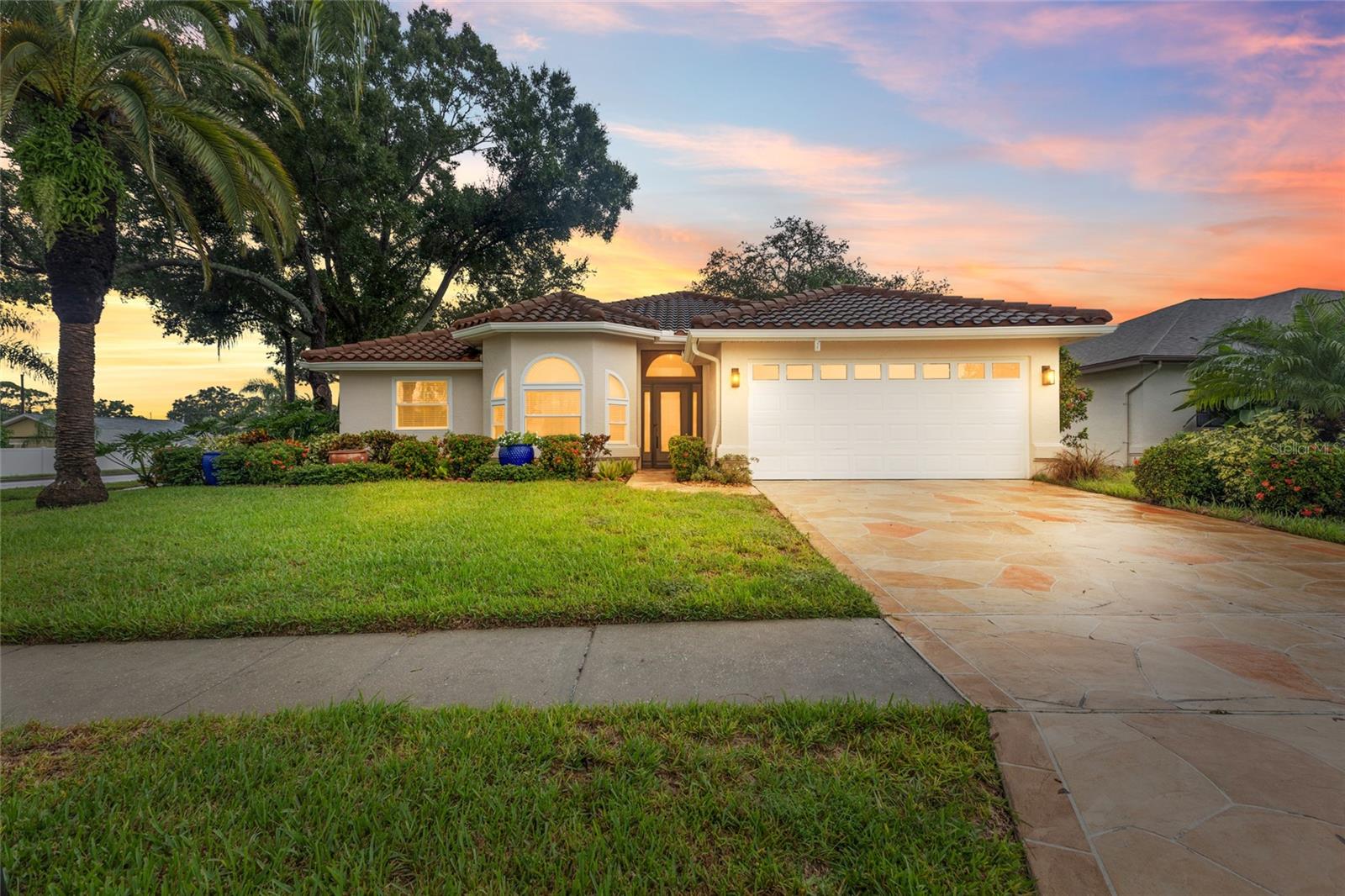 Welcome to your turnkey oasis on the Palm Harbor and Tarpon Springs border! Nestled within a quiet, highly desirable deed restricted community with incredibly low HOA fees, this meticulously updated ~1,900 sq ft home offers the ultimate blend of luxury, privacy, and peace of mind. Boasting an expansive 4 bedroom, 3 full bath layout including two private en suites (perfect for guests or multi-generational living), no detail has been overlooked. Every major system, along with the gourmet kitchen and all three bathrooms, has been completely modernized within the last four years. From the sleek contemporary finishes to the newly upgraded automated sprinkler system that keeps your curb appeal flawless, this property is truly better than new construction.Step through the doors and discover a unique architectural layout designed entirely around a spectacular central courtyard, where nearly every room in the house offers direct access to the pool patio. This seamless indoor outdoor flow leads you straight to your own private poolside paradise, featuring a sparkling saltwater pool that has been beautifully resurfaced and is protected by a brand new panoramic screen enclosure that maximizes your views of the lush surroundings. Backed by all new 2026 pool equipment and complete with a modest covered area on the patio perfect for shaded outdoor dining or escaping the afternoon sun, this low maintenance retreat is ready for year round entertaining. Best of all, you are just minutes away from top rated Pinellas County schools, pristine Gulf beaches, and the vibrant dining, shopping, and culture of the world famous Tarpon Springs Sponge Docks. Schedule your private tour today and step into a lifestyle where absolutely everything has already been done for you!