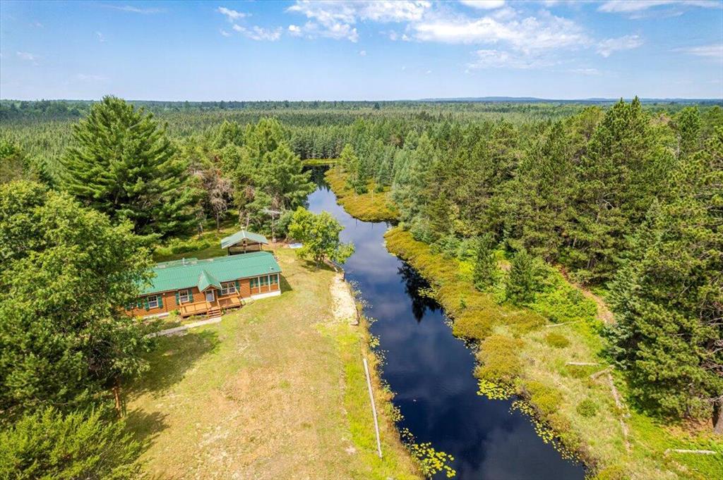 Welcome to 11250 Patricia Lane--a rare and extraordinary opportunity to own 60 acres of prime Northern Michigan land, just 1.5 miles from world-renowned Higgins Lake. Tucked a quarter mile off the paved road along a private drive, this property offers complete serenity, privacy, and incredible access to the Up North outdoor lifestyle. Built in 2003 and recently updated, this 3-bedroom, 2-bath home is clean, comfortable, and move-in ready. A newly added 21' x 6' front porch welcomes you into a warm living space with knotty pine walls, cathedral ceilings, and an open-concept kitchen and dining area. Off the dining room, a renovated enclosed porch provides the perfect spot to take in panoramic views of the pond and surrounding nature.The primary suite features a spacious bedroom, double closets, and a private bath with a jetted tub. Two additional bedrooms, a refreshed laundry/mechanical area, and a renovated enclosed side entryway complete the home's thoughtful layout.

Outdoors, enjoy every inch of your own private pond - perfect for a quiet paddle or early morning fishing. A 12' x 16' covered deck and large firepit area overlook the water, while a 12' x 30' enclosed outbuilding and two covered parking structures offer storage for toys and gear. There's also ample space to build a future pole barn.

This property is a sportsman's dream - a healthy mix of hardwoods and pines with an established trail system and eight hunting blinds already in place. It borders hundreds of acres of State Land to the west and north, expanding your access for hunting, hiking, ORV riding, and snowmobiling.

Whether you're into deer, turkey, or waterfowl hunting, fishing, snowmobiling, ORV riding, or golf at Forest Dunes, this location between Roscommon and Grayling puts it all at your fingertips. It's a 5-minute drive to the North Higgins Lake Boat Launch and just 15 minutes to world-class fly fishing on the Au Sable River. And with a whole-home Guardian by Generac generator and an additional well already installed for potential expans