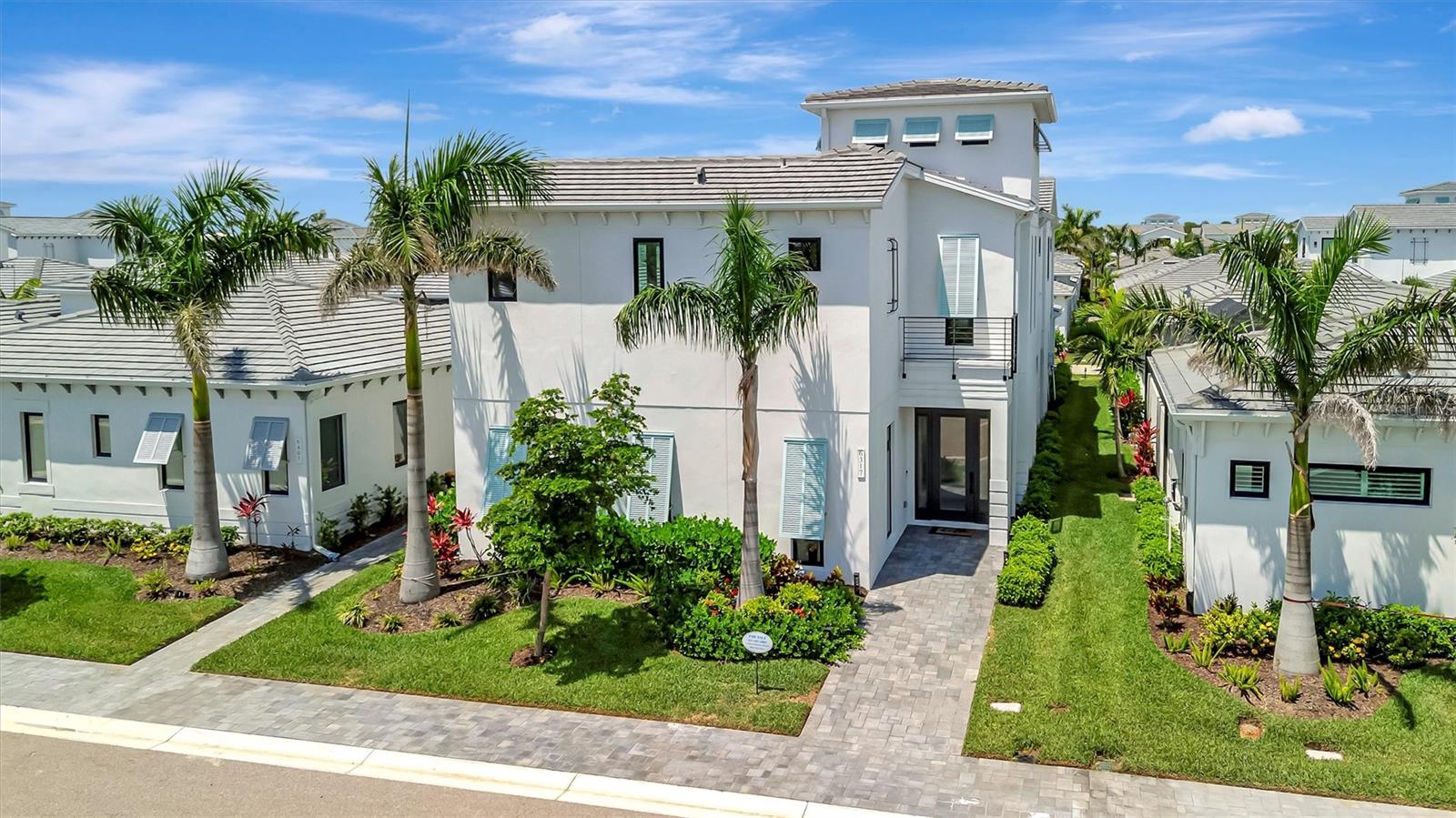 Experience elevated coastal living in this stunning two-story FULLY FURNISHED modern luxury home, ideally nestled in the sought-after Aqua Lagoon community—where tropical beauty meets contemporary sophistication. Spanning 3,916 square feet of meticulously designed space, this architectural masterpiece offers 3 bedrooms, 4 full bathrooms, a versatile loft, an office/den, and a spacious bonus media room perfect for entertaining or relaxing in style. All flexible spaces that can easily be converted to additional bedrooms offering the potential of a 6-bedroom home per the new owner’s preference.  Step inside to soaring ceilings, a custom stairway with sleek lines, and designer finishes that define every inch of this residence. The heart of the home features a courtyard highlighted by a heated saltwater pool with a custom waterfall – truly your own private oasis for sun-soaked afternoons or evening gatherings under the stars. With seamless indoor-outdoor flow, there is direct slider access to an oversized media room as well as the chef-inspired kitchen providing the dream atmosphere for entertainment and family gatherings.  The kitchen is outfitted with premium appliances including a built-in oven and microwave, solid wood cabinetry, a pantry closet, and a natural gas cook top in the oversized island that opens up to living area bathed in natural light. A private office sits just off the living room providing a peaceful retreat for remote work or a convenient flex space for multiple uses. 
Down the hallway is a full-size bathroom with direct access to the pool courtyard as well as a formal dining room space with pool views through the extended windows and additional sitting space under the custom stairwell, perfect for enjoying a good read or conversation.  Upstairs two of the three generously sized bedrooms boast private balconies with views of the serene courtyard and pool, creating a resort-style atmosphere right at home, while the loft offers a flexible space for family living, entertainment, or guest accommodations. In addition to your own private balcony, the master suite features an extended walk-in closet, and a spa-like retreat for the bathroom featuring separate vanities, free-standing soaker tub, and an oversized walk-in shower with dual shower heads. The second bedroom features a en-suite bathroom with shower tub combo and the third bedroom sits conveniently next to a full bathroom.  A full laundry room is located on the second floor for ease of access. New owner will be able to take advantage of the full home UV lighting HVAC as well as a hospital grade water filtration system that runs throughout. The epoxy floor garage with built-in overheard storage, features a rare third flex space that’s perfect for additional storage, golf cart parking, or a third car parking spot. This vibrant coastal community is centered around a stunning 4-acre crystal-clear lagoon, promising luxury, leisure, and lifestyle all in one.  Aqua lagoon is conveniently located near world renowned IMG Academy, IMG Golf & CC, Anna Maria Island, Cortez Village, and SRQ airport, while remaining a short drive away from shopping and entertainment districts such as UTC and St Armand’s Circle. All providing the perfect location and atmosphere for your personal home, private FL retreat, or annual rental investment.  Beat the wait for a new build and schedule your private showing of this stunning FULLY FURNISHE home!!!