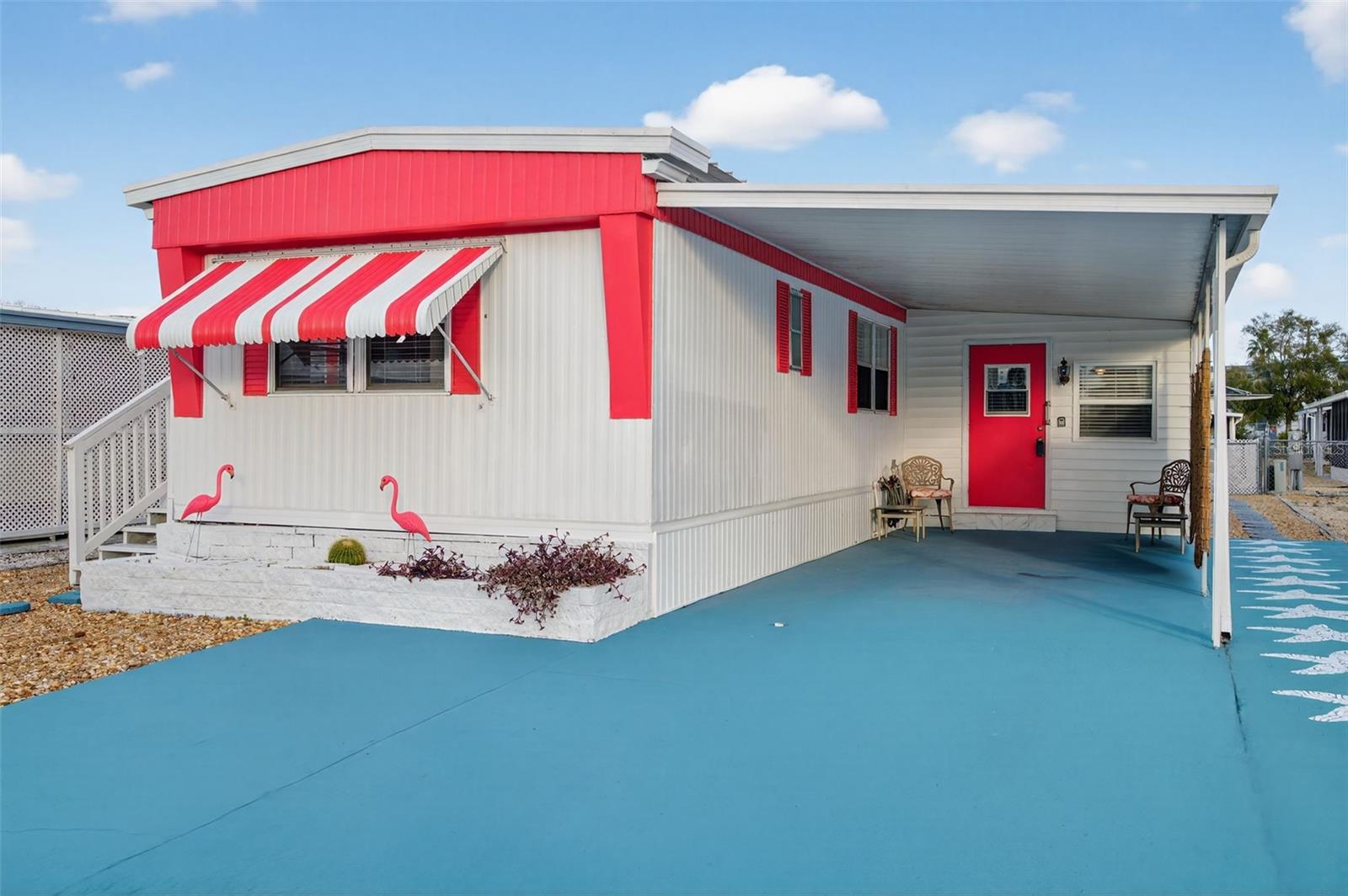 WELCOME TO YOUR MARVELOUS HOME at 12110 Bonanza Dr, Hudson, FL in the friendly 55+ community of Ponderosa Park. This 1979 SINGLE-WIDE manufactured home consists of 2 bedrooms, 2 bathrooms with nearly 1400 total sqft. Key exterior features are the MASSIVE paved driveway painted in a VIBRANT Caribbean blue with stenciled starfish & FLAMINGO PINK accent colors on the home to BRIGHTEN the aura. This is a HAPPY HOME with a feel good TROPICAL vibes! More AMAZING exterior attributes are low maintenance rock yard, long-lasting metal roof, utility storage, private mailbox, rain gutters & hurricane shade shutters as added protection for some windows. There is a BRAND NEW AC SYSTEM installed with proper county permit 12/2025. As you step inside the SPACIOUS Florida room, cooled by a newer built-in AC unit, you will find a SUPER CUTE study/office nook in one corner of the room & the INDOOR washer & dryer laundry machines (included in the sale) in another closet. You'll LOVE how OPEN & CHEERY the interior feels with TERRIFIC floors that dress up the entire home. The WONDERFUL eat-in-kitchen features lots of cabinets with cylindrical handles, stainless steel double sink, SHIMMERY mosaic tile backsplash & nice appliances including fridge, smooth-top range & microwave. There are 2 pantry closets as BONUS storage options. The sea-blue pendant light over the dining area complements the decor. The OVERSIZED living room features a built-in bookcase, ceiling fan & has an exit to the dedicated foyer entrance. The "flamingo house" features the POPULAR split-bedroom plan with each bedroom & FULL bathroom on opposite wings of the home. The primary bedroom consists of DUAL closets, upper cabinets with lock & key & its bathroom in the adjacent room. This full bathroom features cabinet storage, sink, RICH sea-green subway tile backsplash, linen closet & tub/shower combo with sliding glass door. The second bedroom is a PERFECT guest space featuring a PRIVATE EN-SUITE bathroom with sink, toilet & step-in shower with safety handles. Your newly UPDATED, MOVE-IN READY home is sold FURNISHED for your INSTANT ENJOYMENT! Ponderosa Park in Hudson, FL in Pasco County is a MAGNIFICENT community to call HOME where pets are welcome. Included in the low HOA fee of $250 for the YEAR is recreational activities like HEATED POOL, shuffleboard & clubhouse where many social activities take place. Location is IDEAL near beaches, shopping, restaurants, medical plazas, places of worship & tourist attractions. MAKE THIS YOUR FUTURE HOME!