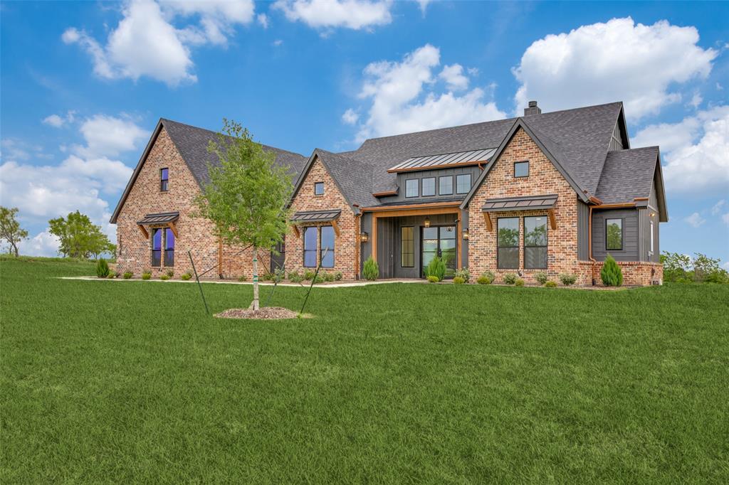 Set on over two acres in Bear Creek Ranch, this Caliber Homes Churchill pairs distinctive architecture with a floor plan designed for the way you actually live. Inside, soaring ceilings and abundant natural light create an impressive sense of space, while warm hardwood floors and carefully selected finishes keep the home inviting. The kitchen makes a statement with custom cabinetry, an oversized range, designer tile, pot filler and substantial wood vent hood, opening naturally to the main living and dining spaces. A dedicated study features dramatic millwork, built-in cabinetry and a vaulted ceiling. The private primary suite includes a beautifully finished bath with freestanding tub, walk-in shower, dual vanities and generous storage. Two additional bedrooms are located on the main level, while the oversized fourth bedroom and full bath upstairs create a flexible guest retreat or bonus space. Outside, the expansive covered patio with wood-plank ceiling and fireplace takes full advantage of the peaceful acreage setting and wide-open views. A 3-car split garage completes this 3,308 sq ft home in Aledo ISD.