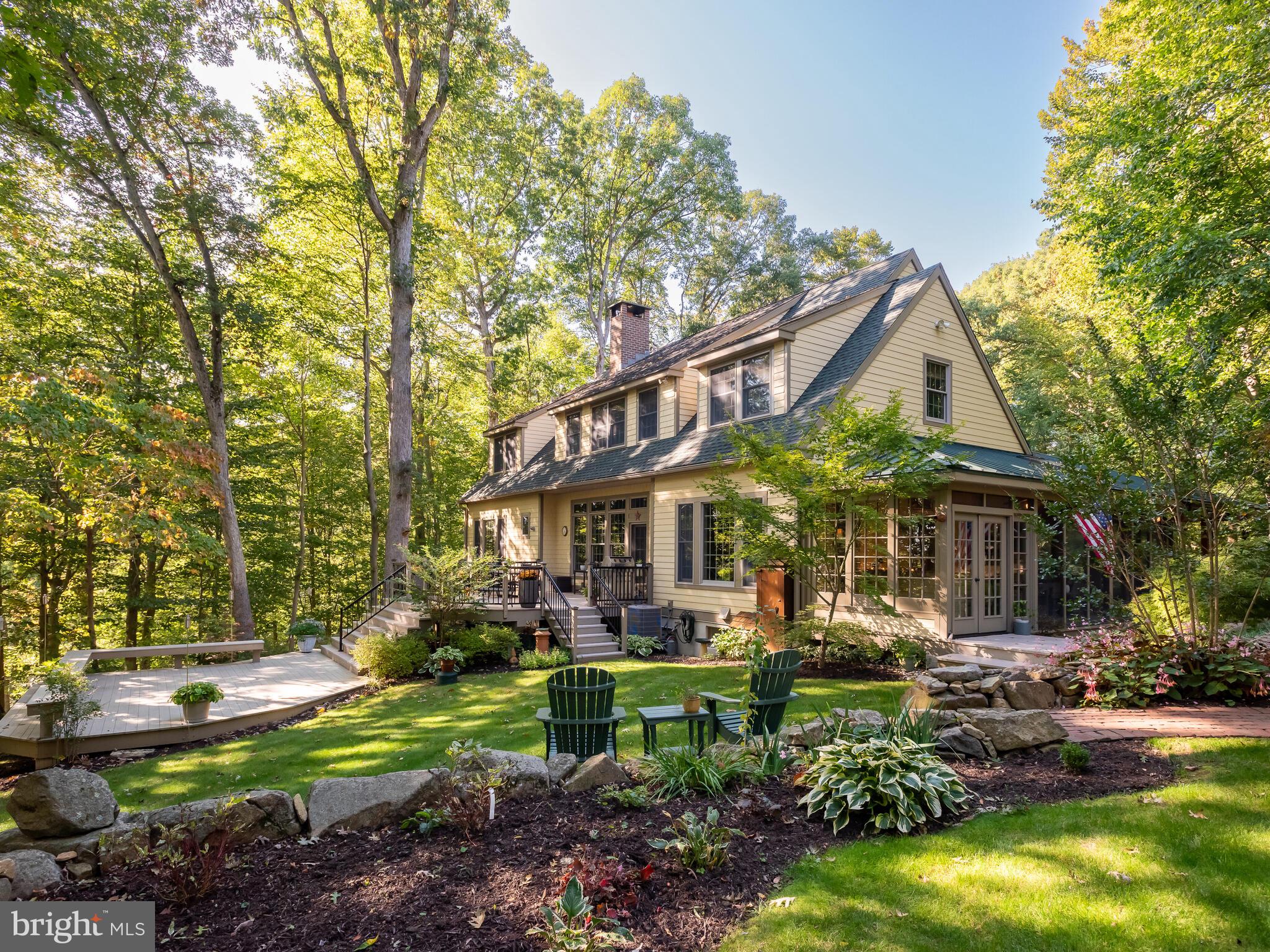 Searching for a slice of quiet rural living w/out sacrificing convenience? From passing the historic stone walls lining the entrance of the driveway, to the moment you drive up to this stunning Craftsman style Cape Cod, you are left in awe. Sitting atop a hill far back from the road, the mature trees & beautiful foliage mixed with historic Chester County charm steal your heart. As you approach the front of the home along the brick walkway, you cannot help but to admire the large covered wrap-around porch w/ multiple areas to enjoy your coffee or wine. Upon entry, the abundance of natural light, modern hardwood floors & open layout w/ 10’ ceilings set the stage for this custom-built home. Off the foyer you will find the spacious family room featuring a Rumford wood burning fireplace w/ arched brick surround & built-in niche for wood storage, built in shelving, large transom windows & a glass door leading to the multi-level back deck w/ gorgeous views of the property. Open to the FR is the very spacious eat-in kitchen creating the perfect space to entertain loved ones for dinner or summer parties of all sizes. The stunning kitchen features custom tall inset cabinets, quartzite countertops, paneled fridge & dishwasher, Thermador gas cooktop, wet bar w/ wine fridge & an expansive island w/ seating. The eat-in area includes views of the back yard & a side entry door leading to the screened in dining porch w/ a dry bar & mini fridge. Off the other side of the kitchen you will find the mudroom & laundry room conveniently located w/ a side entry door leading to the covered porch closest to the driveway. At the opposite end of the home, the luxurious first-floor primary suite is privately situated & includes a sitting room lined w/ windows (allowing for gorgeous views from your bed in all four seasons) w/ a gas stove & access to a balcony & a private screened in porch. The spacious ensuite bathroom has a dual sink vanity, tiled walk-in shower, tub & a walk-in closet. Completing the first floor is a privately located powder room off the foyer. Venture upstairs to the oversized hallway landing where you will find 3 addt’l spacious bedrooms w/ ample closet space (one w/French doors and including stairs to the walk-up attic). A shared hallway bathroom, cedar closet, linen closet & dormer closets complete this level. The finished walk-out basement has French doors to the lower-level paver patio for indoor/outdoor entertaining. Inside is a family room w/ gas stove, plus addt’l space for a game room, playroom, etc. A private room w/ a closet is situated next to a full bathroom at one end of the bsmt. Off the FR is a workout room & an unfinished storage room w/ shelving. An addt’l separate office w/ its own side entry has steps up to the screened in porch nearest the driveway for easy coming/going. The property includes a heated detached garage (40x40) w/ an oversized 4-car bay on one side, & the other side is a drive-through shop w/ 14’ ceilings, 11,000 lb capacity lift, room for 2 vehicles w/ a 3rd vehicle on the lift, as well as half bath, separate 200amp meter & septic tank. Above is add’tl livingspace (800sqft) including a full kitchen & bathroom. This gorgeous property includes plenty of yard space, perennial gardens, a garden shed, & a firepit w/ bench seating & boulders – perfect for hanging out on the crisp nights ahead! The bottom of the driveway splits & includes run-in shed w/ tack room on the lower section of the property. Whole house automatic generator. New Bosch HVAC system installed in 2023 with new thermostat in 2026. Newer roof on main house. New tankless water heater 2023. This home is the epitome of classic elegance & quiet living w/out being far from restaurants, shopping, Schools, Township Park, Marsh & French Creek State Parks, & major routes (PA Turnpike, 322, 82). Prepare to fall in love!