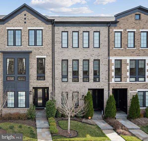 Sophisticated 4-bedroom, 3.5-bath luxury townhome located in the highly desirable West Village neighborhood of One Loudoun. This exceptional residence features hardwood flooring throughout the main level and extended lower-level foyer, soaring ceilings, and a light-filled open-concept design ideal for both everyday living and elegant entertaining.The gourmet kitchen serves as the centerpiece of the home, showcasing an expanded quartz island, abundant cabinetry, a dedicated coffee bar, wine cooler, and generous entertaining space. This model also features a rare office located directly off the kitchen level, offering the perfect space for working from home or a private study area. Just off the kitchen, a covered terrace provides seamless indoor-outdoor living while overlooking the exclusive resident-only park in West Village.The entry level offers 9-foot ceilings and a spacious first-floor suite, ideal for guests, extended family, or additional living space. Upstairs, thoughtfully designed bedrooms feature oversized closets and well-appointed bathrooms, providing both comfort and privacy. A two-car garage adds everyday convenience.Enjoy an exceptional lifestyle just moments from Downtown One Loudoun, with premier dining, shopping, parks, and entertainment just a short walk away, along with convenient access to major commuter routes. A rare opportunity in one of Ashburn’s most vibrant and sought-after communities.