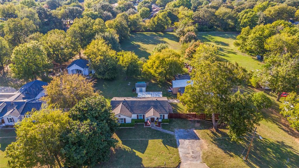 This meticulously maintained residence offers a tranquil county lifestyle in the midst of the metroplex, situated on a spacious 1.272-acre lot. The kitchen was completely renovated in 2019, boasting updated cabinets, granite countertops, LG stainless steel appliances, a gas cooktop, LED under-cabinet lighting, and replaced plumbing featuring PEX lines, drains, and gas lines. Additional updates include new flooring, paint, and a tankless water heater. The bathroom has been refreshed with a tile shower enclosure and a whirlpool tub. A large shop is equipped with a ductless mini-split system, 18,000 BTU Mr. Cool, 100-amp electrical service, and ship-to-shore plugs for an electrical generator. The property is complemented by a metal cedar fence, metal carport, and electric gate.