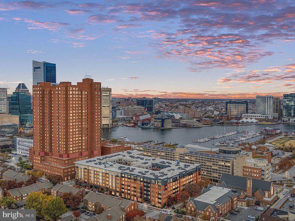 REDUCED! Welcome to The Towers at Harbor Court- a coveted luxury hi-rise condominium located in Baltimore's vibrant Downtown/Inner Harbor area.  This rarely available  3-bedroom + den, 2.5-bathroom model offers over 2,100 square feet of living space, with expansive rooms and spectacular panoramic city views. Includes new white oak flooring.  The heart of the home is the recently remodeled gourmet kitchen, a chef's delight with quartz countertops,  under-cabinet lighting and top-of-the-line appliances including a Wolf induction stove, Cove dishwasher, and GE Café refrigerator, plus thoughtfully designed extra storage space (with room for a freezer), ample pantry and convenient newer LG washer and dryer.  New electric hot water heater.The spacious primary bedroom suite features multiple built-ins and a stunning bath with separate tub, oversized shower, dual granite topped vanity and magnificent city views. One bedroom has extensive built-ins for use as an office. Extensive storage and closets throughout other rooms.   An airy and light filled living and dining combination area features ambient modern lighting, new chandelier and floor-to-ceiling windows with views of the harbor, the promenade and Aquarium.   Harbor Court offers exceptional service and a wealth of amenities. With 24/7 front desk coverage, a uniformed doorman, porters, security, maintenance staff, secure deeded parking (one space), and additional personal storage, every need is thoughtfully addressed. This stable and prime Inner Harbor location also gives residents access to the adjacent Royal Sonesta Hotel, including optional membership at the fitness center and pool/spa.  For those seeking effortless living in a luxurious, amenity-filled environment, The Towers at Harbor Court is a must-see! Positioned near the Inner Harbor, this residence offers proximity to cultural landmarks, diverse dining, and walkable to sports and entertainment venues.