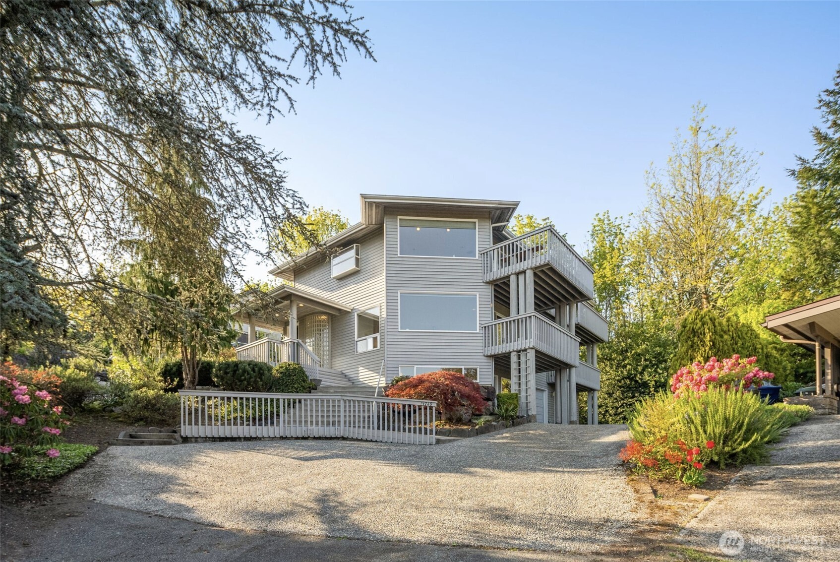 Stunning custom home with peek-a-boo mountain and lake views! Nearly 4,000 sq ft of beautifully designed living space on just under a half-acre in a peaceful, private setting that truly feels like you’re living on top of the world. The open floor plan is filled with natural light and features an enormous kitchen perfect for cooking, gathering, and entertaining. A second potential kitchen on the main level offers incredible flexibility—ideal for multi-generational living, hosting guests, or creating a separate living space for possible rental income. Versatile bonus room provides the option of a home office, gym, guest space, or potential 4th bedroom. Thoughtfully designed for comfort and accessibility, the home also features a private elevator connecting levels and a relaxing spa, perfect for unwinding while enjoying the peaceful surroundings. Enjoy outdoor living with four decks, a lovely yard with garden spaces, abundant storage, and RV parking. Major updates include a new roof, new gutters, new exterior paint, and a new hot water tank for peace of mind. Conveniently located near the Burke-Gilman Trail, schools, Lake Forest Park Town Center, and with easy access to I-5, I-405, and Hwy 522 for commuting in any direction. A rare combination of space, views, and flexibility, this exceptional home is ready to welcome you!