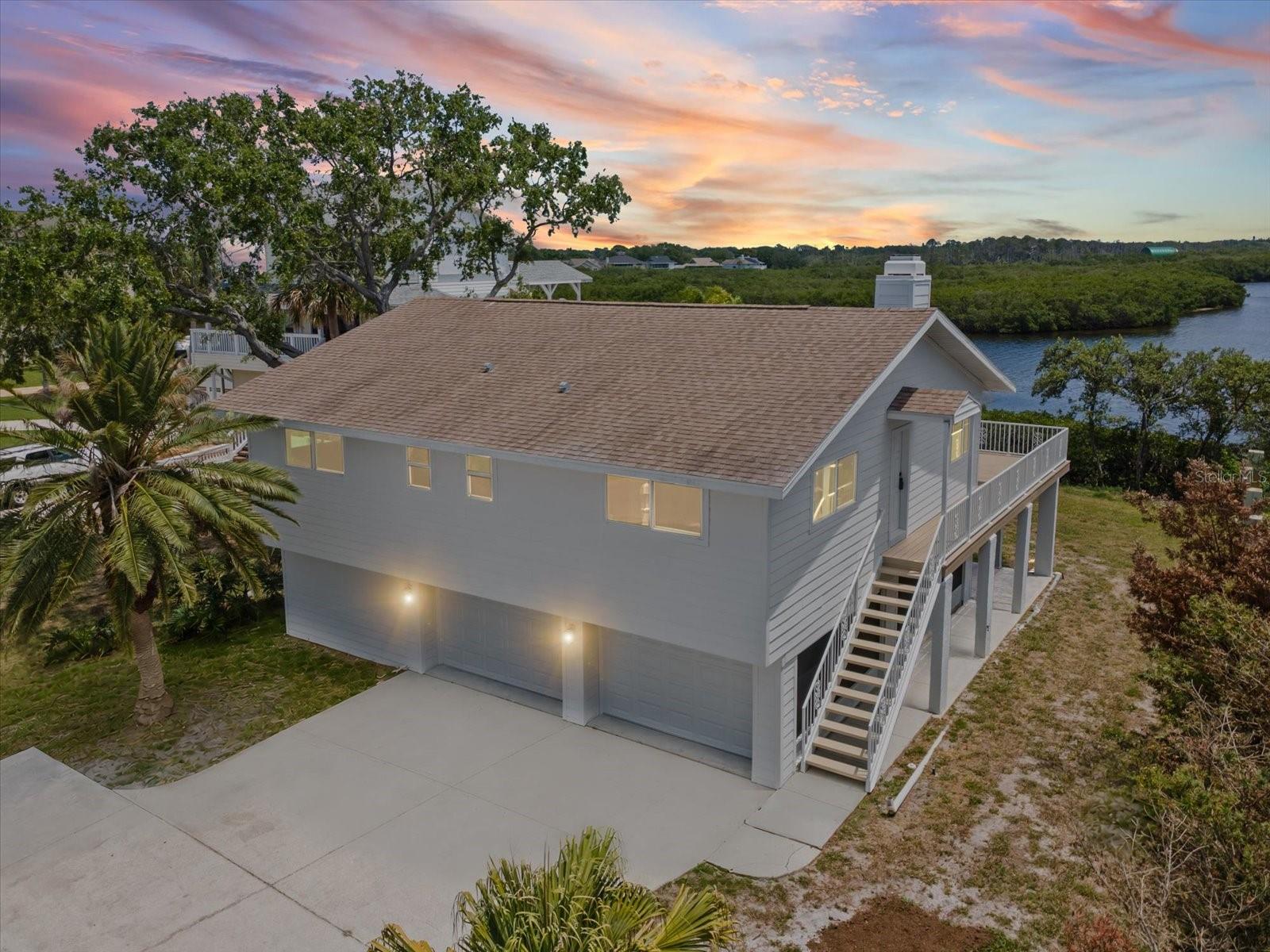 One or more photo(s) has been virtually staged. Welcome to your slice of paradise on the Gulf of Mexico, where every day ends with a breathtaking sunset over the water. This charming 2-bedroom, 3-bath elevated home captures the essence of coastal living — bright, open, and full of character.Inside, you’ll find a bespoke kitchen filled with light, natural textures, and modern touches that make cooking feel effortless. The living area flows beautifully with beamed ceilings, a cozy fireplace, and wide windows framing stunning views from Howard Park to Clearwater.Step outside to the expansive deck and savor the salt air, sea breeze, and endless horizon — perfect for morning coffee or evening gatherings under the stars. Below, the first-floor screened area provides bonus space ideal for relaxing in the shade. Flex rooms provide storage for your paddleboards and kayaks after a day on the water.  Moments from the historic Sponge Docks, fresh seafood restaurants, and Tarpon’s vibrant local culture, this home offers a rare blend of Old Florida charm and modern coastal comfort — a peaceful retreat that feels truly one of a kind.  Hurricane rated windows and sliding doors. Lower level is not included in square footage
