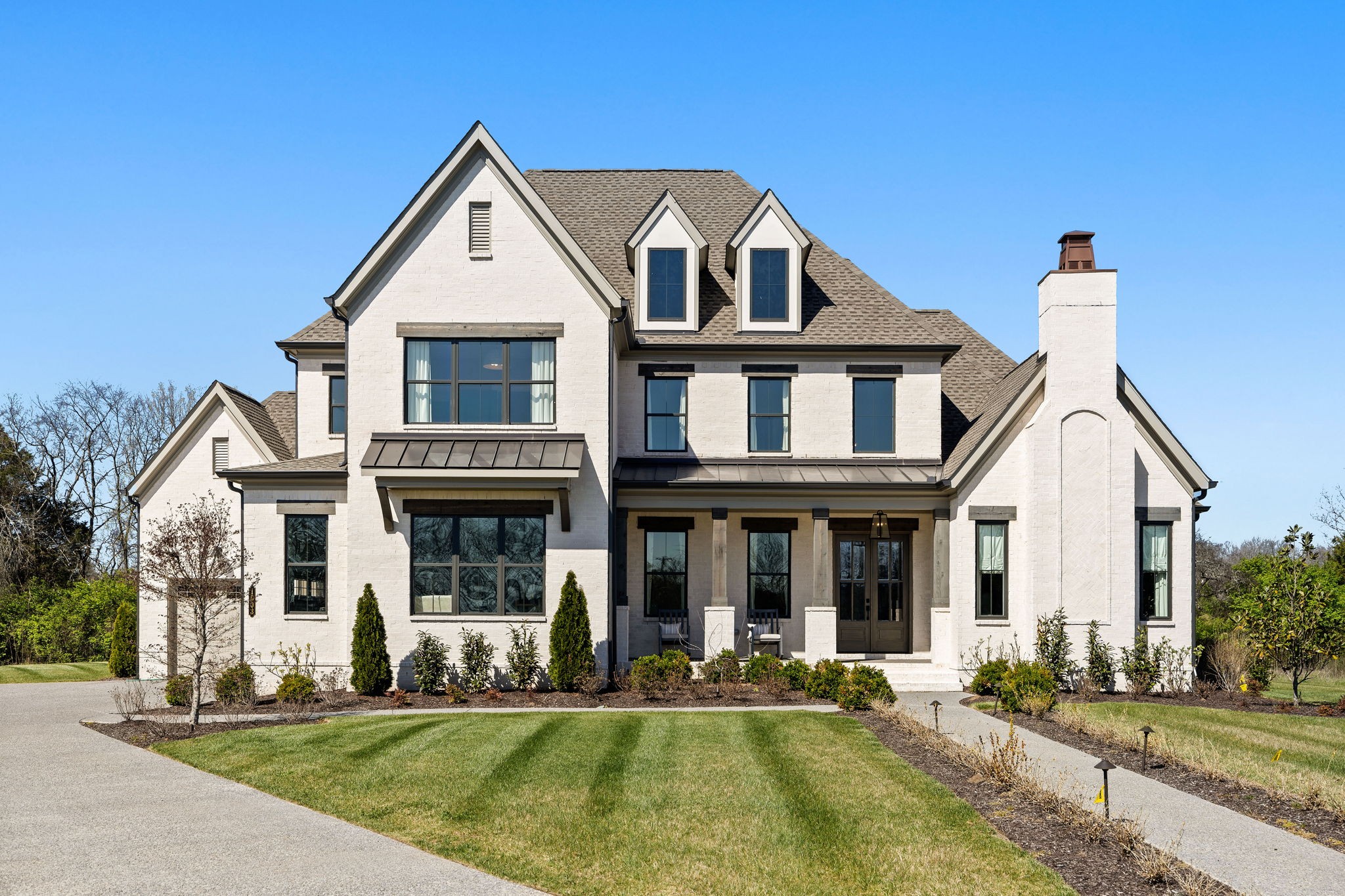 Sinatra Model Home Now Available - All appliances, bedding, draperies, rugs, and mounted televisions to remain, making this an exceptional, move-in-ready opportunity. Experience exceptional craftsmanship and effortless, elevated living in this beautifully appointed Turnberry model home, thoughtfully designed with an open floor plan featuring both the owner’s suite and a guest suite on the main level. Striking designer lighting, curated finishes, and refined architectural details are showcased throughout, while expansive windows fill the home with natural light and enhance the seamless flow ideal for both everyday living and entertaining. The family room is a true focal point, highlighted by custom built-in cabinetry and floating shleves, and architectural ceiling beams that add warmth and character to the space. The main level is designed for ultimate convenience, offering the primary living areas, a stunning vaulted study with built-in bookshelves and a fireplace, chef’s kitchen, dining room, entertaining spaces, owner’s suite, and an additional guest suite—all thoughtfully located on one floor. An expansive laundry room elevates daily living with abundant cabinetry, generous workspace, a dedicated dog wash, and a built-in dog feeding area—combining style and functionality for both homeowners and their four-legged companions. Step outside to an inviting covered porch and stamped-concrete entertaining terrace complete with a fireplace, while an encased patio with outdoor kitchen, and firepit—perfect for morning coffee, alfresco dining, or relaxing fireside evenings. Upstairs, three additional bedrooms are complemented by a generous bonus room with entertaining wetbar and beverage refrigerator. A large walk-in storage room provides exceptional space for seasonal items, décor, and luggage. Situated on a homesite surrounded by common space gives lots of privacy, this home offers a peaceful, serene setting just minutes from shopping, dining, and everyday conveniences.