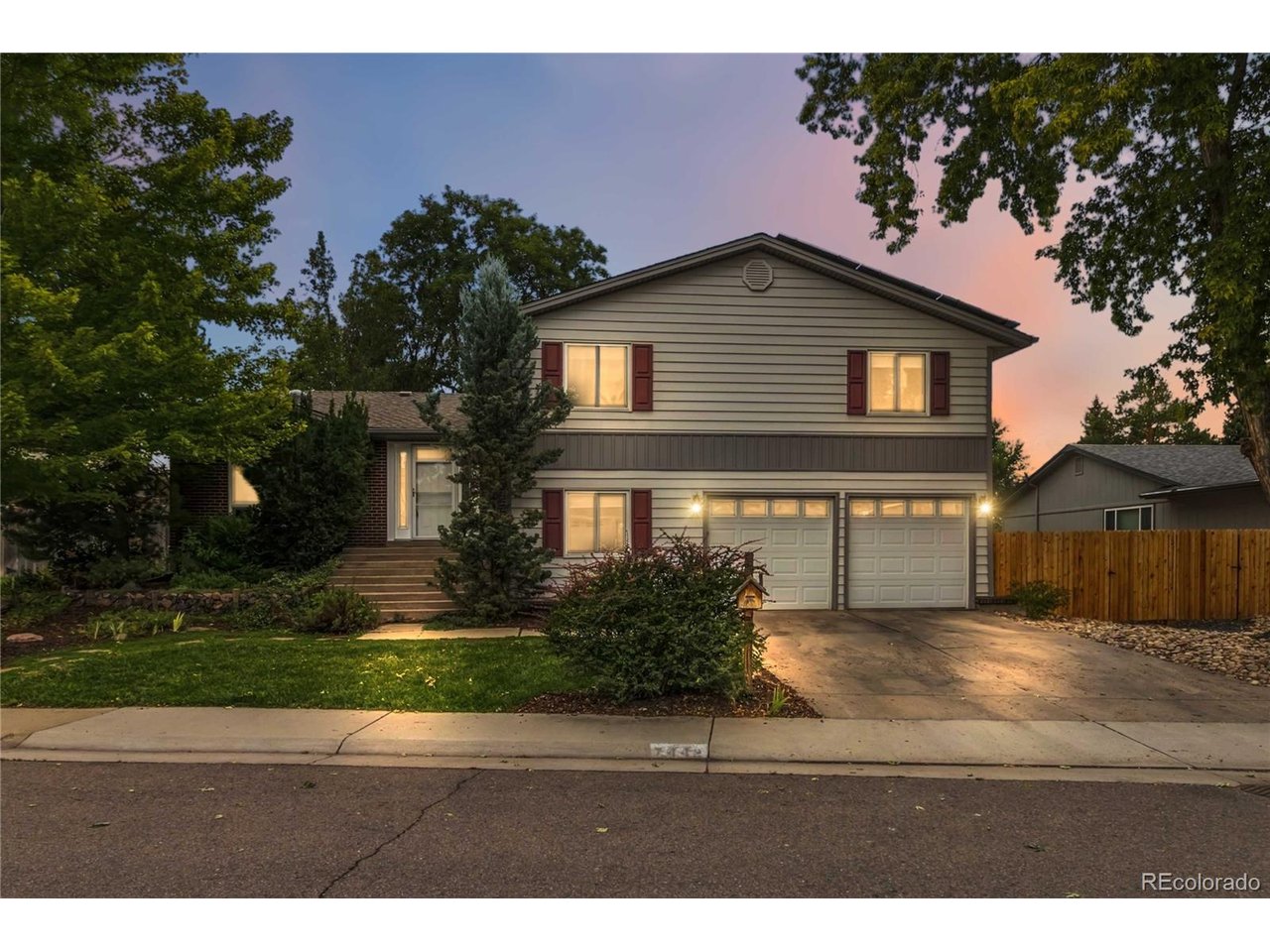 Nestled in an established Arvada neighborhood of Lake Arbor, this well-maintained split-level home offers a versatile floor plan, thoughtful updates, and exceptional indoor and outdoor living. Soaring ceilings and skylights in the living room, dining room, and kitchen fill the main level with natural light, while the spacious living room features a cozy fireplace and bamboo flooring extends into the dining area. The kitchen offers abundant cabinetry, granite countertops, a large island, pantry, and an open layout ideal for everyday living. Hunter Douglas Top-Down/Bottom-Up honeycomb shades provide flexible light control throughout. Upstairs, the spacious primary suite features generous closet space and an updated three-quarter bath with double vanities and a skylight, while two additional bedrooms share a full bath with a skylight and ample storage. The lower level includes a fourth bedroom, three-quarter bath, and laundry room with a 220V outlet. The unfinished basement is freshly painted and drywalled, offering excellent storage and the opportunity to finish the space to fit your needs. Outside, enjoy a fully fenced backyard with multiple gathering spaces, an expansive covered Trex deck, storage shed and plenty of room for gardening, entertaining, or relaxing. Additional highlights include hot tub ready pad with electrical hookup, an extended two-car attached garage, a whole-house fan for energy-efficient comfort during Colorado's mild spring and fall seasons, new furnace and water heater with expansion tank (2022), central A/C (2023), and a timeless brick exterior.