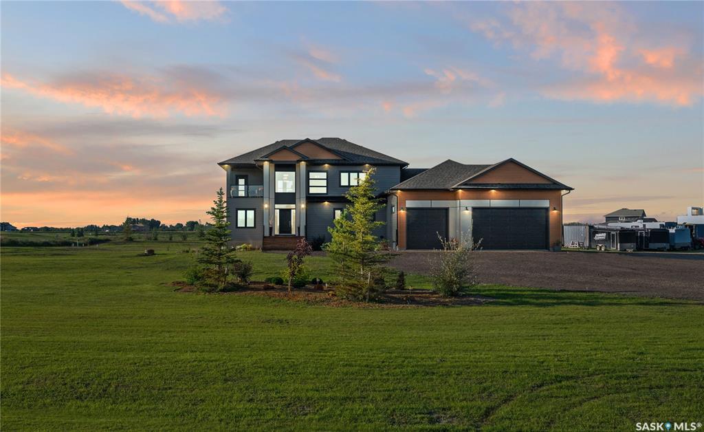 Welcome to 172 Grandview Trail, an exceptional residence in the prestigious Grasswood Estates. Set on three acres, this custom-built home combines modern design with functional elegance, offering four bedrooms, four bathrooms, and a spacious five-car attached garage. The interior is thoughtfully designed with high-end finishes throughout. The chef’s kitchen is a true highlight, featuring acrylic cabinetry, quartz countertops, a built-in double oven, a gas stove with a pot filler, and a convenient butler pantry. Perfect for entertaining or everyday living, the open layout flows seamlessly into the living room, where a striking stone fireplace, custom built-ins, and expansive windows create a bright and welcoming atmosphere. The home itself is supplied with city water, ensuring convenience and reliability. The bedrooms are generously sized, designed with both comfort and style in mind. The bathrooms feature granite countertops and spa-inspired finishes, offering a retreat-like experience in your own home. The fully developed lower level provides even more living space, complete with a large family room, stylish bar area, private theatre, and a gym that can also serve as a versatile fourth bedroom. Step into the backyard made for both entertaining and unwinding. The three-tier deck with a built-in pizza oven provides multiple areas to host friends and family, while the meticulously landscaped grounds feature underground sprinklers and a drip irrigation system sourced from the well to keep everything vibrant and low-maintenance. Whether enjoying summer gatherings or quiet evenings under the prairie sky, this outdoor space is designed for every occasion. With its striking modern design, spacious five-car garage, and carefully crafted interior, this home perfectly balances luxury and functionality. Situated just minutes from Saskatoon, yet offering exceptional privacy and room to roam, this home provides the ideal combination of estate living and city convenience.
