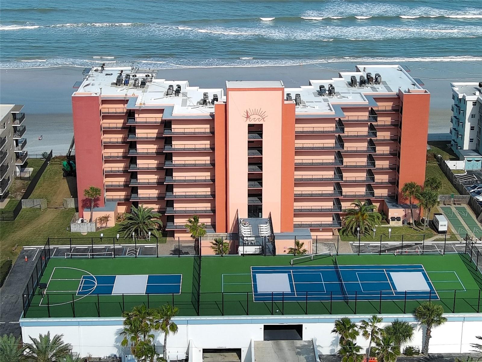 Beautiful Beachfront fully remodeled Condo, this immaculate, move-in-ready, furnished, direct oceanfront condo checks every box. Enjoy breathtaking ocean breezes and unobstructed views of the sparkling sands of New Smyrna Beach and the Atlantic Ocean from the private balcony overlooking the desirable no-drive beach.  This unit has been completely updated, featuring a brand-new kitchen and bathrooms along with luxury vinyl flooring throughout the entire condo. The kitchen showcases beautiful new quartz countertops, stainless steel appliances, and new cabinetry—all enhanced by spectacular ocean views. The updated bathrooms feature fresh tile and quartz-topped vanities, creating a clean, modern coastal aesthetic.Sunrise Condos are very well maintained and have outstanding community amenities, including a pool, tennis courts, basketball and shuffleboard courts, new pickleball courts, plus the convenience of an in-unit washer and dryer. Ideally located near New Smyrna Beach’s best dining, shopping, and entertainment, this exceptional oceanfront condo is truly a must-see.