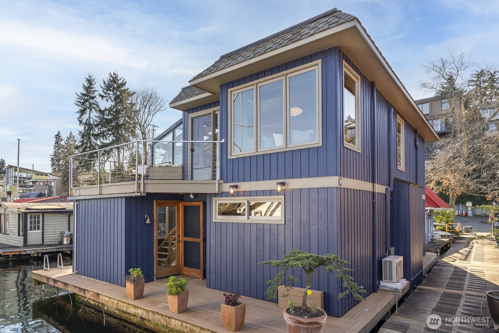 This remarkable floating home on Portage Bay isn’t just a residence — it’s an invitation to experience the quintessential Seattle waterfront lifestyle. Tucked at the quiet end of a dead-end street, the home offers panoramic views and seamless indoor-outdoor living with decks on both levels. Thoughtfully designed and updated throughout, the open main floor features a chef’s kitchen, brand-new quartz countertops, newer appliances, solarium dining area over the water and custom window seat perfect for relaxing. Two bedrooms, 1.25 baths, a office space, and a laundry room create a layout that balances comfort and flexibility. An atrium staircase adds architectural charm, while fresh paint and hardwood floors create a warm and inviting space. Moorage, accessory float, dedicated parking space, additional storage, shared garden and woodshop complete this special retreat. Located within the Houseboat Harbor cooperative — known for its welcoming community and no HOA dues — this is a rare opportunity to enjoy iconic waterfront living in the heart of Seattle.