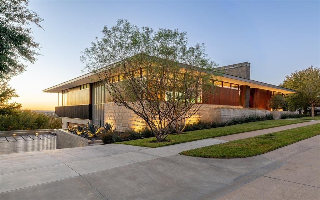 An Icon, Reimagined. Welcome to 3736 Aviemore Drive, a striking expression of modern architecture defined by precision, innovation, and refined living. Sculptural lines and rare materials converge to create a residence that is truly one of a kind in the region. The exterior makes an immediate statement, blending clean geometry with warmth through Quantum windows and doors, Accoya and Sapele wood accents, and a thoughtfully layered material palette. The main level is designed for effortless daily living, featuring four en suite bedrooms alongside the primary living spaces. Expansive accordion doors open seamlessly to an elevated outdoor terrace, extending the living area into the treetops and framing panoramic views and unforgettable Fort Worth sunsets. Thoughtfully designed indoor and outdoor staircases create a fluid connection between levels, while a private elevator provides seamless mobility throughout the home. The lower level offers a second living and entertaining space, with accordion doors opening to an expansive outdoor entertainment area—ideal for hosting and relaxed gatherings alike. Inside, the home unfolds with a gallery-like flow anchored by a Bulthaup kitchen appointed with Gaggenau appliances and Miele refrigeration. European oak flooring, Starfire glass, and exceptional craftsmanship are evident throughout, from Dornbracht fixtures to custom Drophouse fireplaces. Amenities include a concealed 1,200-bottle wine room, private theater, and a wellness suite with sauna, complemented by over 2,900 square feet of covered outdoor terrace and patio entertaining space. Smart home features include Control4 automation, Lutron lighting and shades, heated floors, and integrated displays throughout. Thoughtfully refreshed and returning to market with a renewed presence, this extraordinary residence is curated for the utmost luxury, convenience, and accessibility—offering features unseen in Fort Worth history and standing as a true architectural masterpiece.