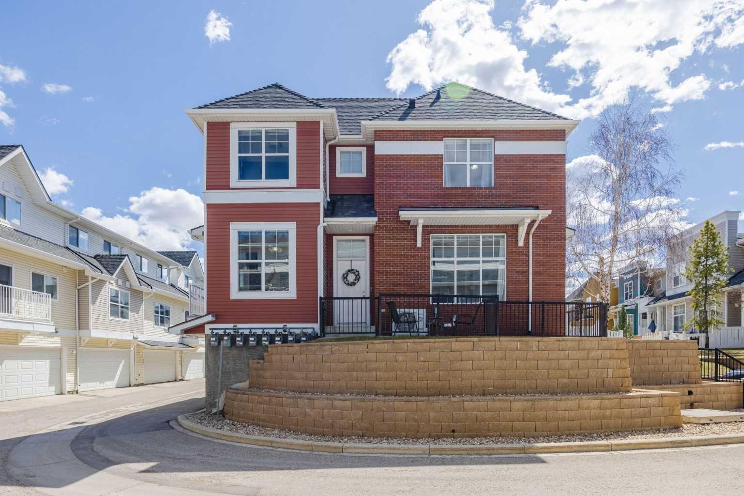 This coveted end unit is an architectural standout that defies the "townhome" label and looks more like a "Castle On a Hill"! Inside, the two-storey layout unfolds into a Open-Concept living space where high ceilings and massive windows flood the home with natural light. The Kitchen & Dining Area feels like its own special space, yet is wide open to the rest of the main floor.  Upstairs, the Master Bedroom is simply MASSIVE yet still allows for an oversized Main Bath and two ample secondary Bedrooms.  One if its most functional features is the full sized Mudroom and Laundry.  It’s accessed directly from the double attached garage yet brilliantly hidden, keeping the mess of daily life, pets & sports gear completely out of sight from your guest-ready living spaces. The lifestyle here is unmatched. Start your mornings with a peaceful stroll around the nearby serene pond, or wander over to High Street for a coffee, an afternoon of local shopping, or dinner at one of many local pubs & restaurants. When you need to venture further, regional shopping is just minutes away. Plus, with immediate access to both Stoney and Deerfoot Trails, your commute to anywhere is effortless. Experience the perfect blend of regal curb appeal and everyday convenience. This isn't just a home; it's your “Castle On a Hill”