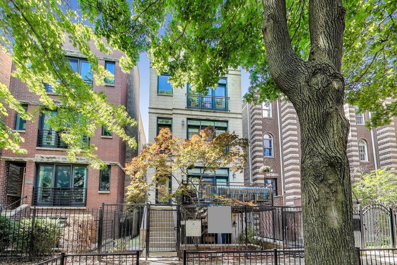 Welcome to 2145 W Crystal St Unit 1 - a spacious and stylish 4-bedroom, 3.5-bathroom triplex nestled on a picturesque, tree-lined street in the heart of Wicker Park. This oversized unit lives like a single-family home with multiple levels of sun-drenched living space and an ideal layout for both relaxing and entertaining.    The main level features an open-concept living and dining area anchored by a sleek fireplace and lined with oversized glass block windows, creating a bright and airy atmosphere. The chef's kitchen is outfitted with granite countertops, stainless steel appliances, an island with bar seating, and a dedicated dining nook.    Upstairs, you'll find two generously sized bedrooms, including a serene primary suite with a walk-in closet and spa-like ensuite featuring a dual vanity, walk-in shower, and soaking tub. A full hallway bath serves the second upstairs bedroom.    The lower level offers two additional bedrooms, a full bathroom, and a large laundry room with side-by-side washer and dryer plus storage space.    Outdoor living is seamless with a spacious front balcony off the main level and a private patio-your personal urban retreat. One garage parking spot, with exclusive electric charging station, is included.    Enjoy unbeatable proximity to Wicker Park's best dining, shopping, transit, and nightlife. This is city living at its finest!