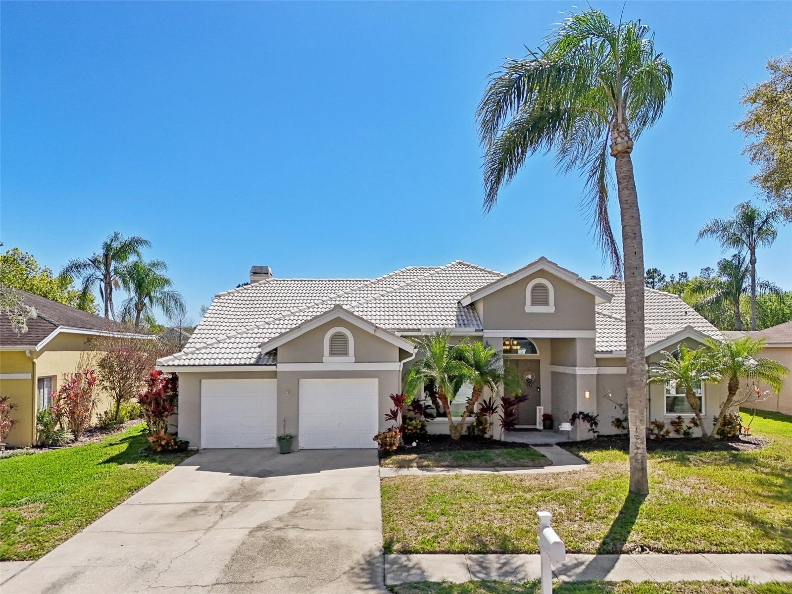 Welcome to your dream oasis in the highly desirable Woodfield community of Tarpon Springs! This beautifully crafted 4-bedroom, 2-bathroom, 2-car garage home perfectly blends luxury, comfort, and indoor-outdoor Florida living. Backing up to a tranquil pond with no rear neighbors, this property offers unmatched privacy.The heart of the home features a light-filled living room framed by soaring ceilings, skylights, and a cozy wood-burning fireplace—ideal for gathering with family or entertaining guests. The living area flows effortlessly into the kitchen, anchored by sleek, durable epoxy countertops that deliver a contemporary high-end feel.Designed as a true sanctuary, the split-bedroom plan places the primary bedroom privately away from the secondary rooms. Enjoy direct sliding glass door access to the pool deck and a luxurious en-suite bathroom equipped with dual separate vanities, private water closet, soaking tub, and a walk-in shower with dual shower heads. The 3 additional guest bedrooms are impressively appointed with walk-in closets and elegant double-edge molding that creates a tray-ceiling effect. Bedroom 4 features its own dedicated sliding glass doors leading straight to the pool lanai. The full guest bathroom boasts a double vanity and convenient direct pool access, keeping wet footprints off your main living floors. Located in the sought-after Woodfield neighborhood of Tarpon Springs, you are minutes away from world-famous Gulf beaches, the historic Tarpon Springs Sponge Docks, top-rated schools, parks, dining, and shopping.