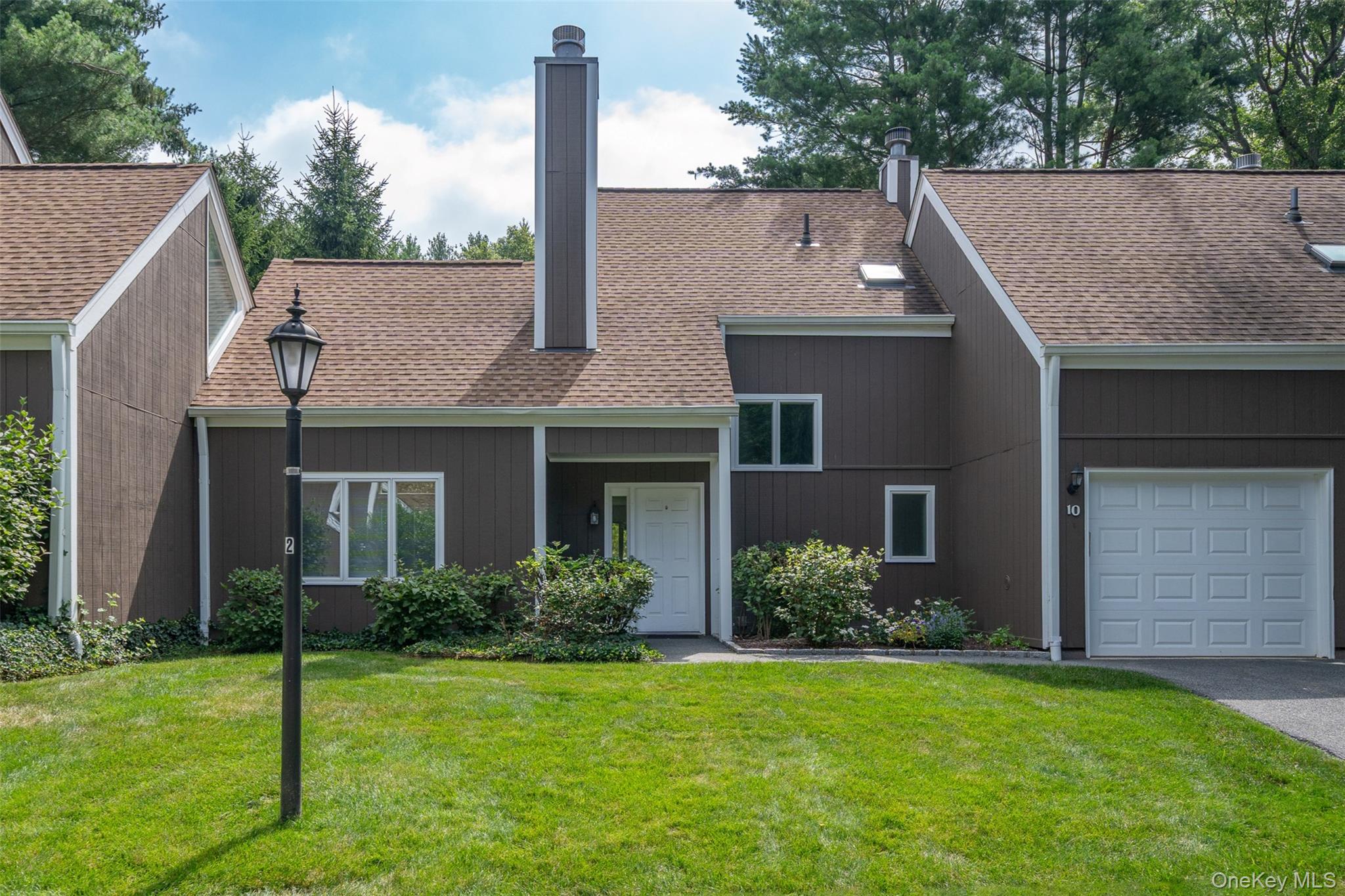 Move right in to this 2-bedroom + loft, 2.5-bathroom townhouse in the highly sought-after Chappaqua School District. Freshly painted throughout and updated with brand-new quartz countertops, new dishwasher and new kitchen flooring, this home offers immediate comfort with the flexibility to personalize. The dining area features sliding doors that open to a grassy green space, while the kitchen sliders lead to a patio—both perfect for indoor-outdoor living. There’s also exciting potential to remove the wall between the two rooms to create a bright, open-concept layout with a center island or breakfast bar. The living room impresses with soaring double-height ceilings and oversized windows, filling the space with natural light and architectural appeal. Major updates already completed include all new windows, roof, skylight, sliding glass doors, AC, and furnace (all replaced approximately 2018). An attached one-car garage provides everyday convenience, while the Apple Hill Farm community offers amenities including a pool and tennis courts. Ideally located just minutes from town, train, and schools, this home combines move-in readiness with the opportunity to customize in a prime setting.