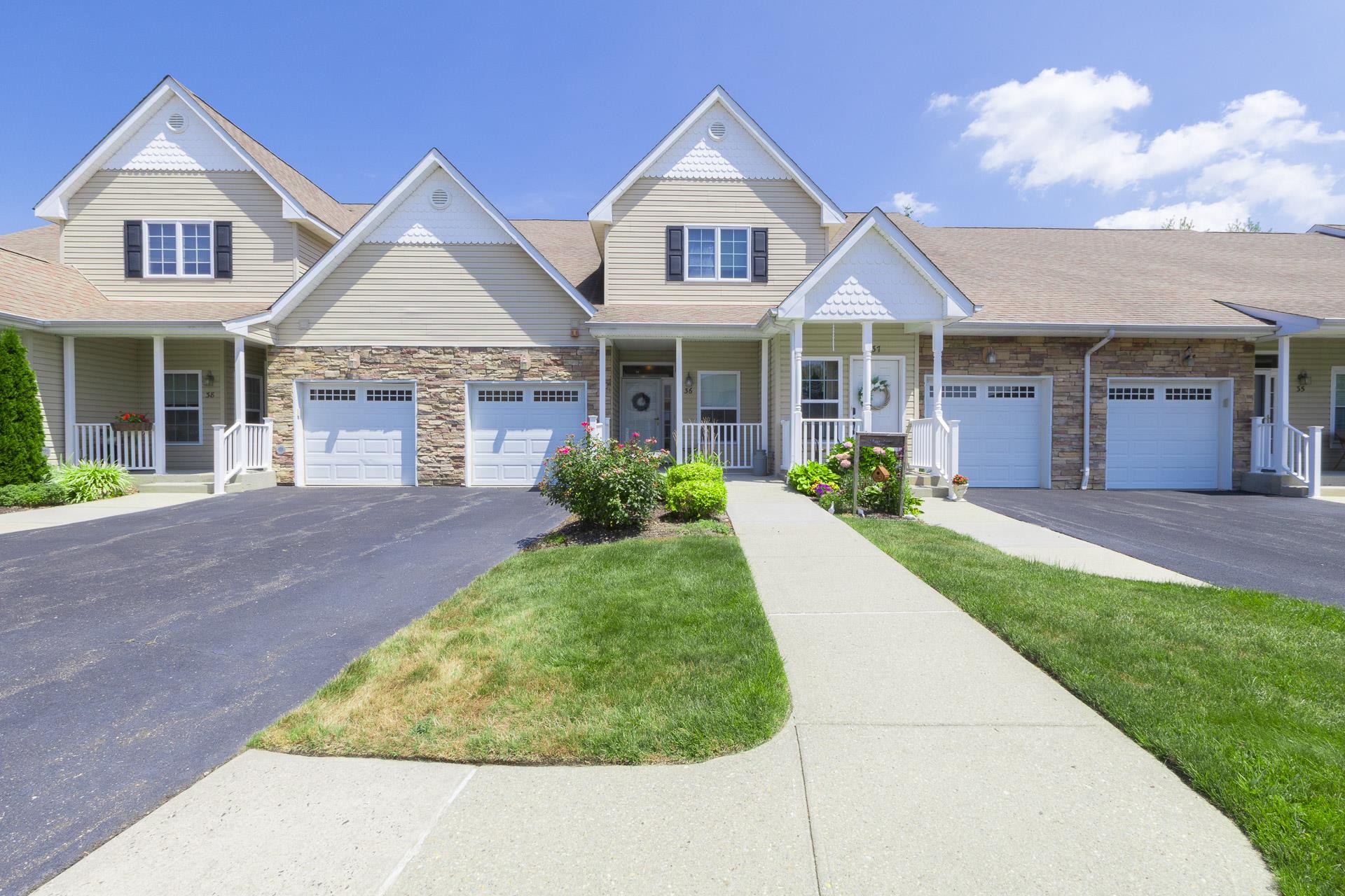 Move right into this meticulous, desirable lower unit. Pride of ownership can be seen throughout this turn key property.Sit outside on  the front porch or on the back, private patio. The attached, interior accessible garage allows for storage as does the full, unfinished basement. The   beautiful wood floors , gas fireplace, open floor plan and large master bedroom enhance the beautiful style of living in this 55 and over, active community. The master bedroom has a bay window, walk in closets and a large bathroom with a walk in shower. The second bedroom is adjacent to the second bathroom which is perfect for guests. The kitchen has granite countertops, cherry cabinets and an island with additional seating. Amenities include a club house, pool, tennis, pickleball, shuffleboard, bocce ball and putting green. Your privacy is assured as there is always security at the owner pass activated entrance gate.