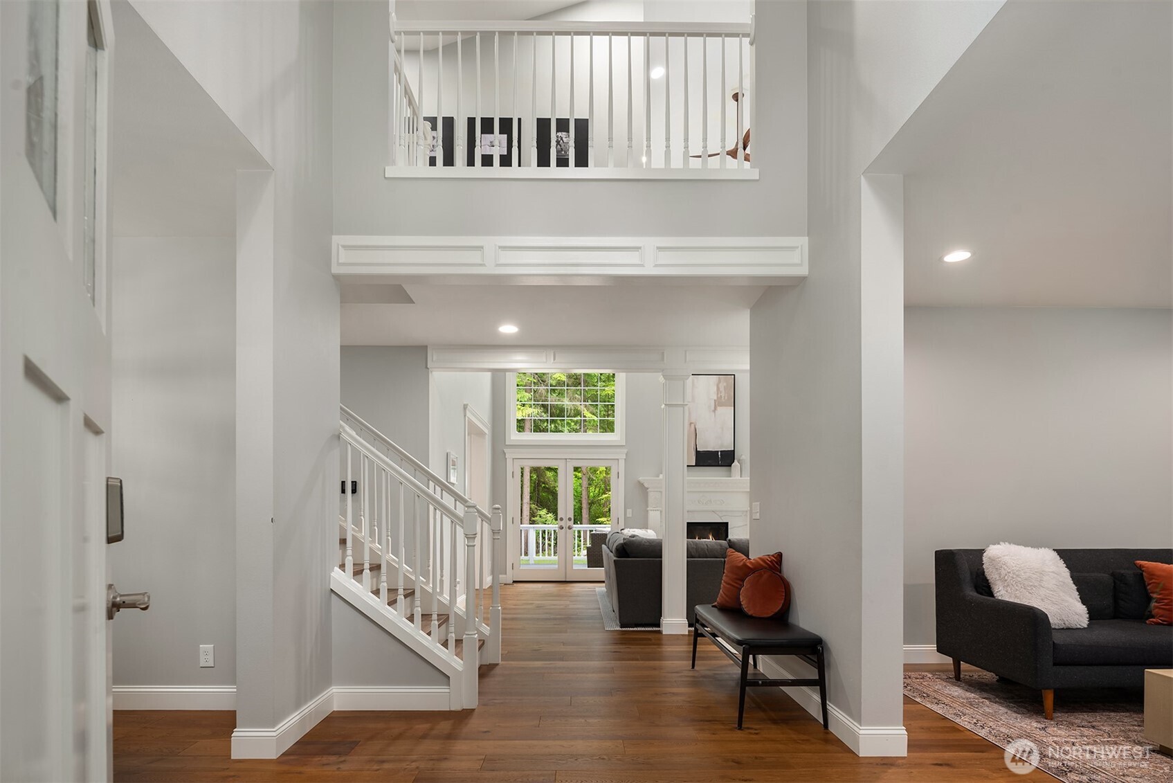 Walls of windows and soaring ceilings fill the great room with natural light, creating an inviting gathering space overlooking the private backyard.