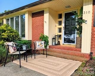 Welcome to this charming mid-century ranch home nestled in a quiet community on a spacious ½-acre lot! This home is move in ready with updates to the bathrooms and removal of wall paper.  New carpet as well.  Garden enthusiasts will love the established planting areas, mature shade trees, privacy-fenced backyard and covered rear porch—creating a wonderful setting for relaxing, gardening and outdoor entertaining.Step through the beautifully crafted solid-wood front door into a home filled with natural light from an abundance of windows. Hardwood floors extend throughout much of the home and, per the seller, are also beneath the carpet in at least two of the bedrooms. The inviting living room features a handsome solid-wood fireplace mantel with coordinating built-in cabinetry. Enjoy the 12' baseboards giving a nod to days gone by.  An additional room just off the living area provides flexibility for a formal dining room or home office.The expansive eat-in kitchen offers abundant solid-wood cabinetry and new flooring.  Just off the kitchen, a largemud room with laundry/pantry area provides generous storage and a convenient utility sink.Beyond the oversized, finished two-car garage is an additional 387 sq. ft. of finished, heated and cooled space with a private entrance and separate HVAC source. This versatile area is not included in the home’s primary heated living area and offers exciting possibilities for a home office, studio, recreation space, guest retreat or other flexible use.Outside, you’ll find plentiful parking, Inside the private back yard you'll have room to enjoy grilling, gardening and entertaining with covered porch space and open paver patio area. Yard is fenced as well.  Additional features include a vapor barrier in the crawl space.New gutters, some new windows and new water heater and furnace.Gas fireplace conveys as-is. Driveway is shared. Browdis Street ROW.  Priced to sale, don't miss this one!
