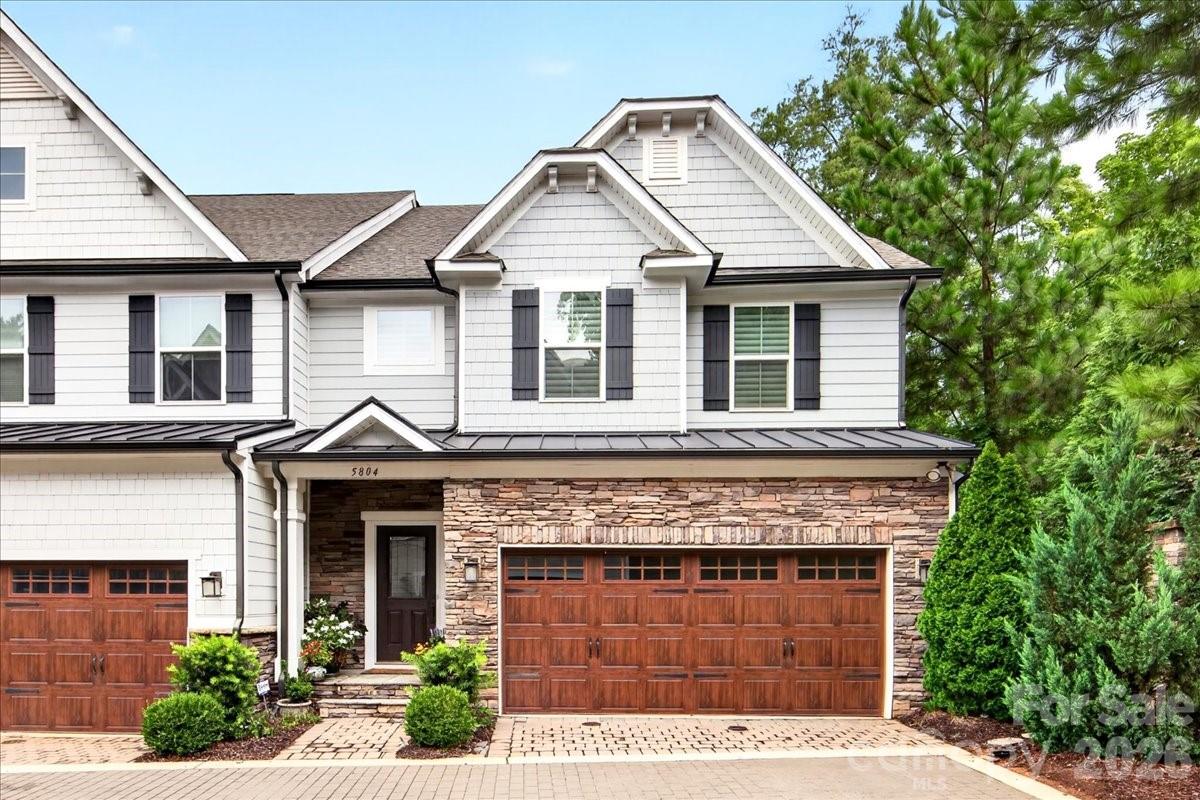 Welcome to this elegant 3 bed/ 2.5 bath SouthPark townhome in the coveted Sharon Acres community! The primary suite on the main level features a tray ceiling, an ensuite bath with double sinks, tiled shower with a bench seat, and a large cedar lined closet. Upon entering the townhouse, the 2 story foyer with wrought iron spindled staircase leads to upstairs and the main level. It is accented by vaulted ceilings. The kitchen is a chef's dream with 42" shaker cabinets, granite countertops, stainless steel GE Profile appliances, and a 5 burner gas range which includes a griddle, plus a Bosch refrigerator. The dining area includes built in cabinetry with glass doors. Also added is an extra storage closet and cubby under the staircase. Motorized blinds in ALL rooms guarantees privacy when desired, along with motorized black-out shades. Upstairs, a versatile loft/ flex space overlooks the living area accompanied by two bedrooms and a full bath. The two car garage has built in storage shelving. The garage entry leads to the laundry/ drop zone and a powder room, plus an added desk including an under counter fridge. This end unit has a wonderful enclosed patio. Prime location near SouthPark Mall, Whole Foods, and plenty of dining and shopping options. Don't miss this!