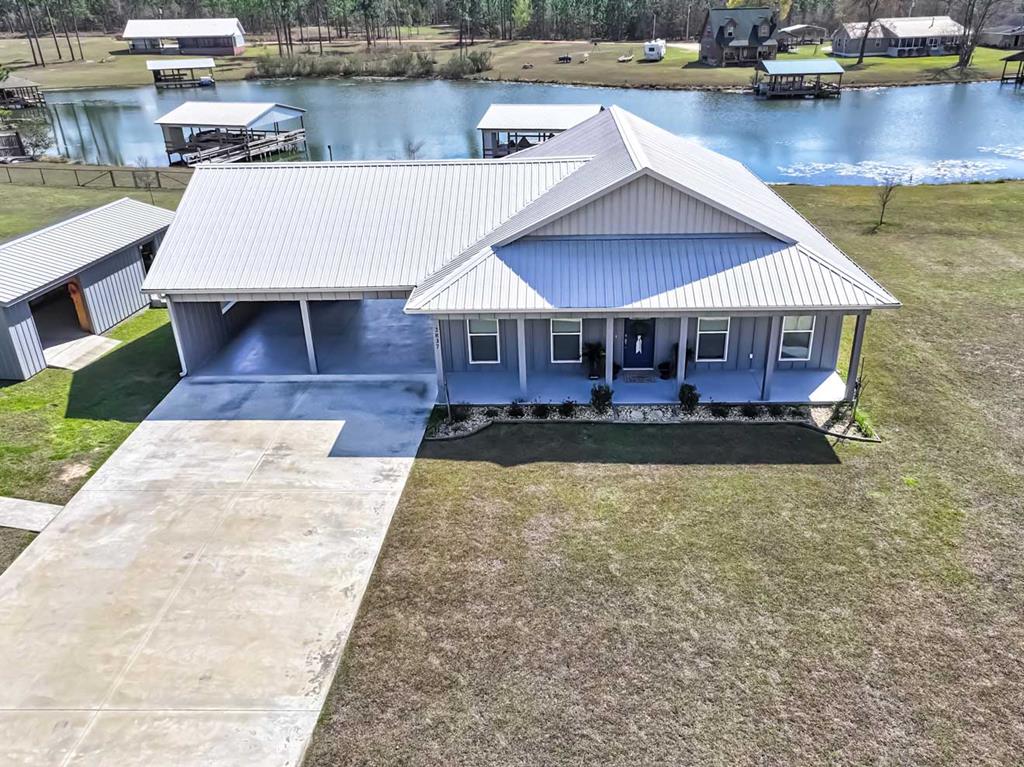 Experience lakefront living at its finest with this well built only 4 year old home on fish pond drain at Lake Seminole. Here you find top tier fishing, hunting and boating. From this location you are just a quarter-mile from the big lake, where you can see the dam at Chattahoochee. This meticulously built home features an open floor plan with 9-foot ceilings, tile flooring throughout, and a spacious living room and kitchen with abundant cabinets and quartz countertops. The bedrooms are large with walk-in closets, and the owner's suite is both roomy and accommodating. Solid wood interior doors, steel exterior doors, and sunshades hidden behind curtains add to the home's quality and comfort. Outdoors, enjoy Deese Elite flooring with a life time quarantee on front and back porches and walkway. A 2-car carport with insulated walls is easily convertible into additional living space. A storage room with HVAC, insulation, electricity, a 20x20 attached porch, and roll-up door is perfect for adding another bathroom, bedroom or serving as a home office. Additional storage is located above the carport. The home's exterior includes hardiboard siding with 5/8” plywood backing, extra insulation, and 5/8” rods every 8 feet inside the walls. The metal roof sits over 5/8” plywood sheeting with rubber mat under tin and is secured with pressure treated 1 x 4's. Metal gutters are installed on the exterior. The  house has 26-guage metal roof, the two additional structures feature 29-gauge metal roofs, including a 14x30 building with an 8-foot roll-up door for outdoor toys or lawn equipment. A 30x30 covered boat dock with electric and water accommodates boats up to 20 feet. It includes an automatic lift and storage room with lighting. The dock is bolted down on pressure-treated pylons and features metal trusses; permits transfer to the new owner. The Army Corps of Engineers maintains the lake. This property is perfect for entertaining, relaxing, and enjoying the lake lifestyle—grill or unwind on the back porch, host gatherings at the dock, fish right off the water, and take in breathtaking sunsets, all while enjoying the craftsmanship, comfort, and thoughtful amenities of this extraordinary home. The State Park is just down the road and is perfect for camping friends, or accommodate them with a hookup next to the outdoor workshop. This neighborhood is restricted against mobile homes so it keeps quality and values up. An additional 0.5-acre lot next door is available for purchase.